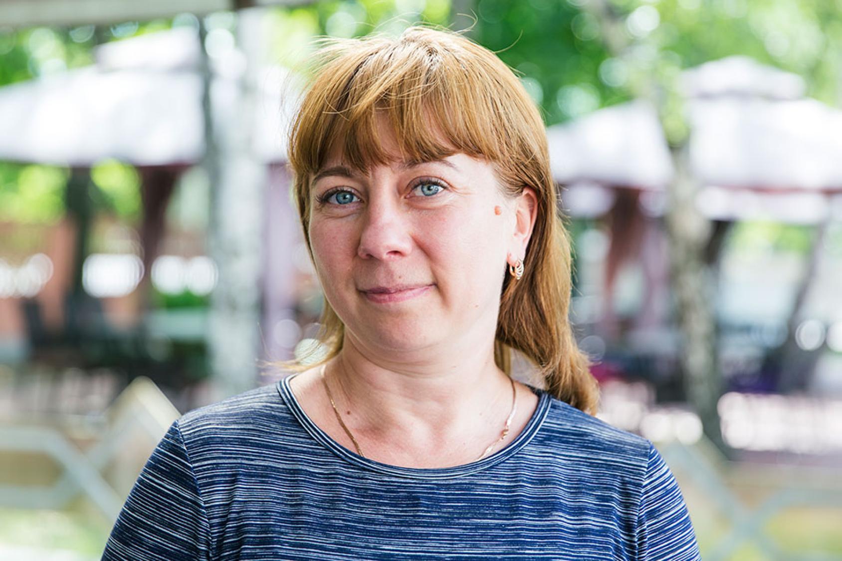 امرأة ترتدي قميصًا أزرق تنظر مباشرة إلى الكاميرا.