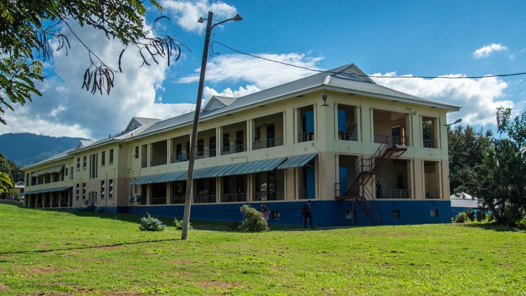 Una imagen de un edificio amarillo en un hermoso día soleado.