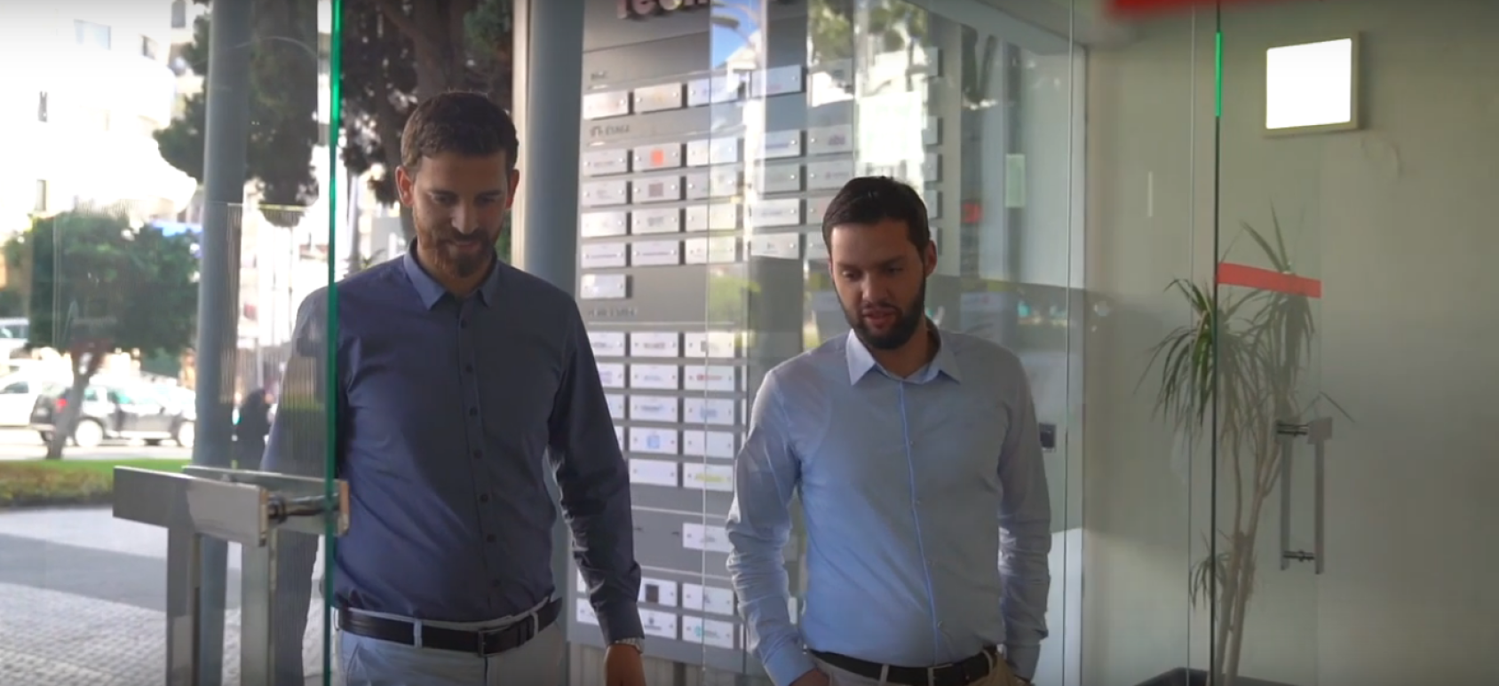 يسير رجلان عبر باب زجاجي.