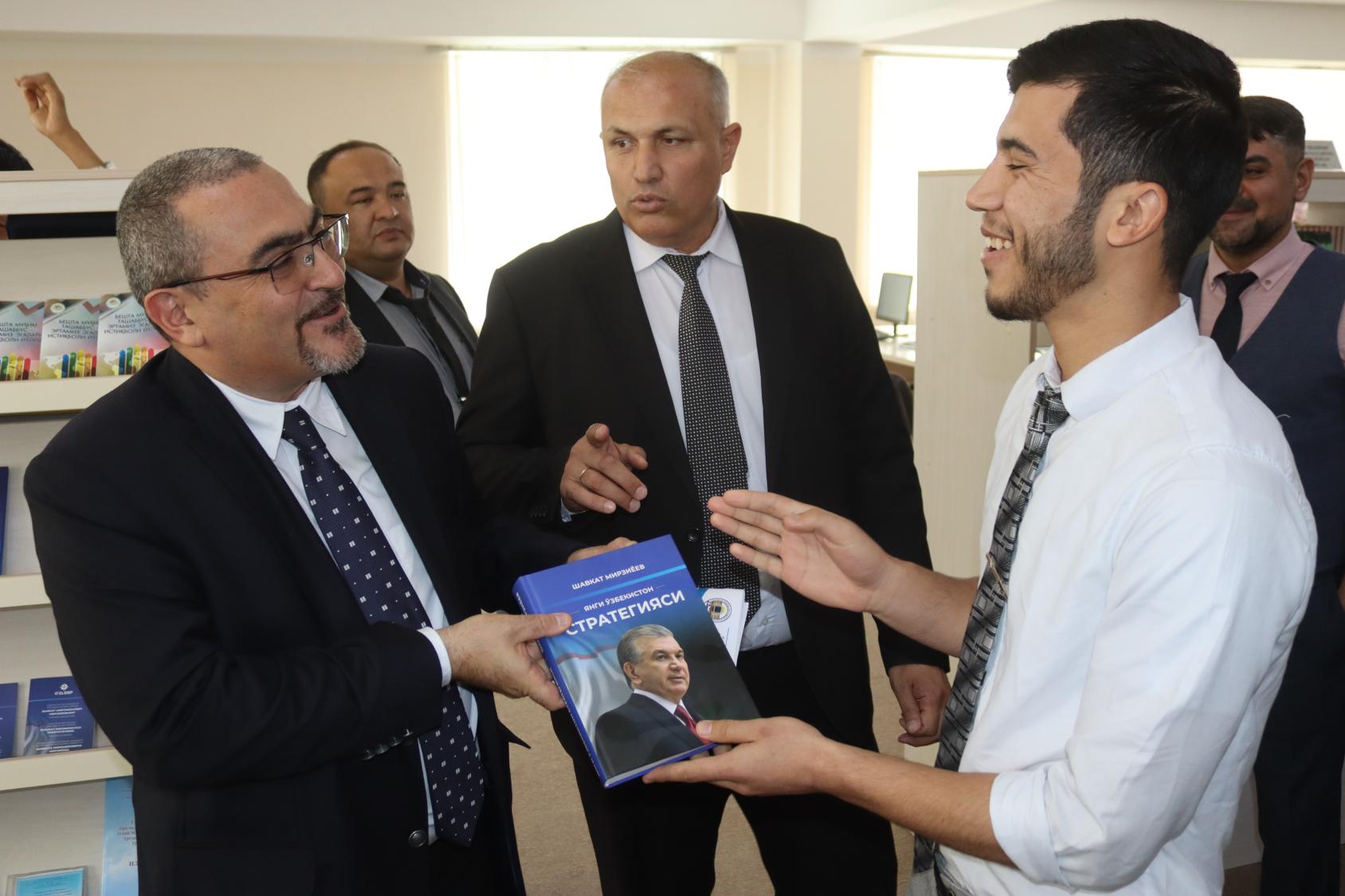 يقدم الطالب في المركز التعليمي في ترميز أحمد جافيد أنيس لمنسق الأمم المتحدة المقيم ومنسق الشؤون الإنسانية في أفغانستان الدكتور رامز الأكبروف، كتابًا ترجمه من الأوزبكية إلى الباشتو.