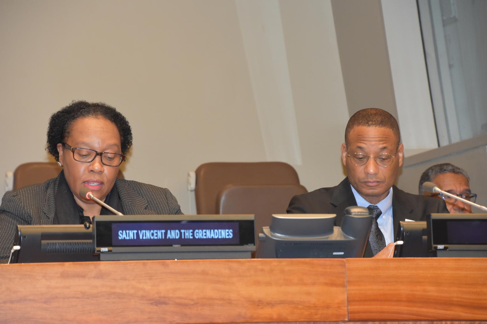 Una mujer y un hombre hablando por los micrófonos en un acto de las Naciones Unidas.