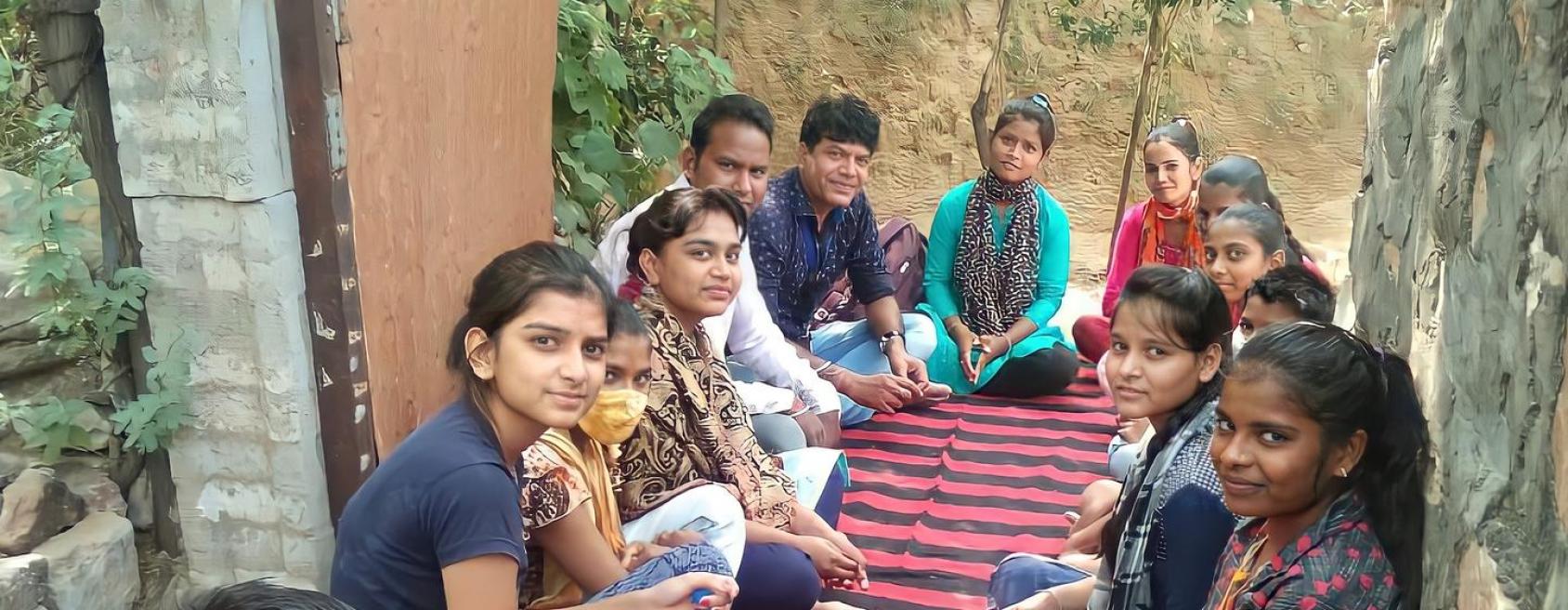 مجموعة من الأشخاص يجلسون معًا ويبتسمون للكاميرا.