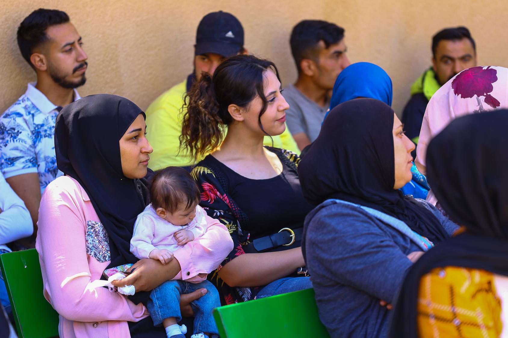 Una mujer sostiene a su niña pequeña durante la ceremonia de graduación del curso de formación basado en competencias dirigido por la OIT en el valle de Beqaa, el Líbano.