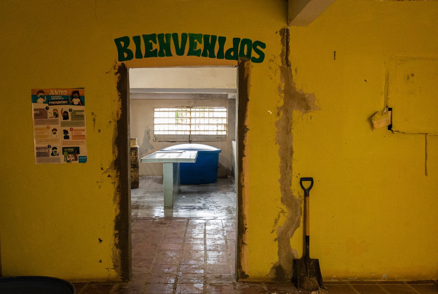Puerta de entrada de una cocina escolar que está en proceso de su rehabilitación, con cambios en su infraestructura y equipos.