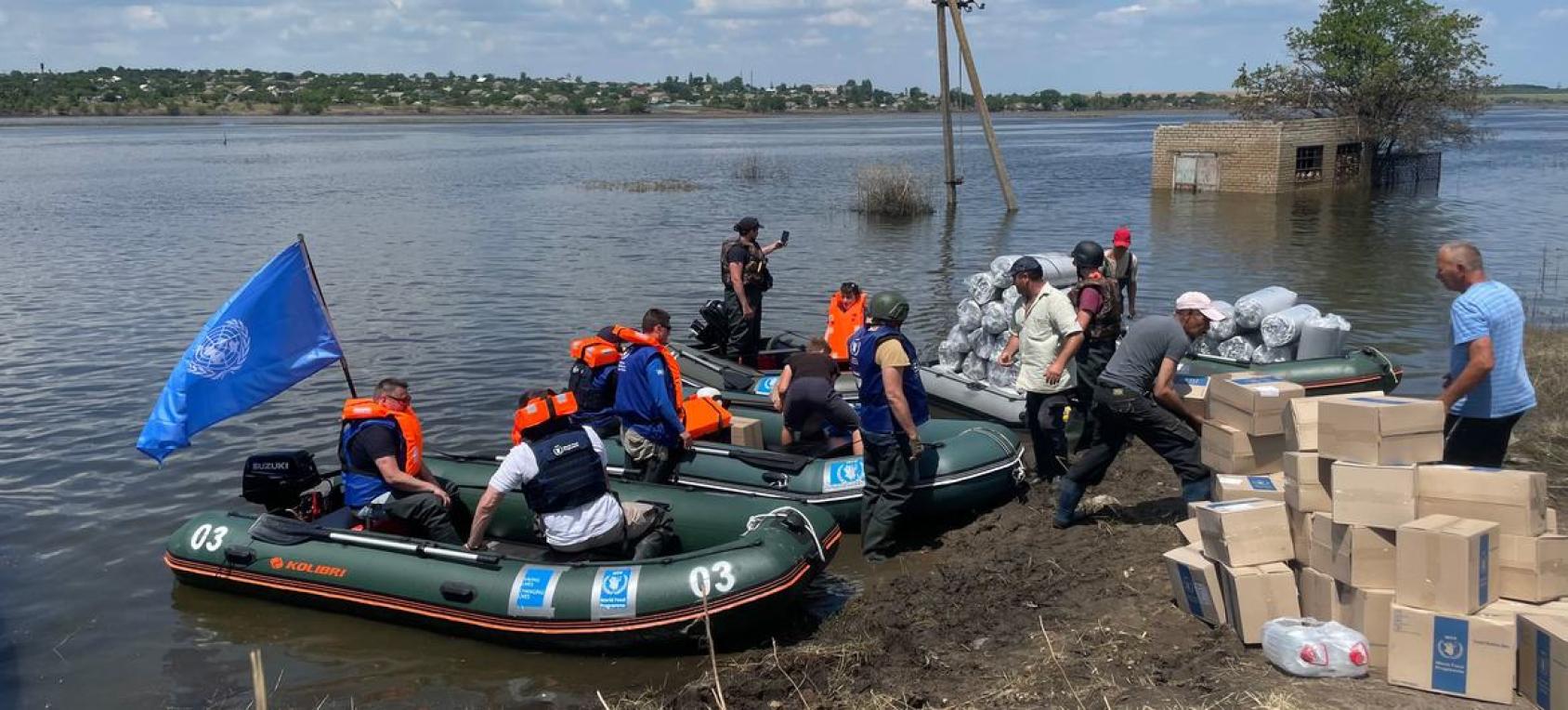 People haul boxes out of two boats in Khersom, Ukraine