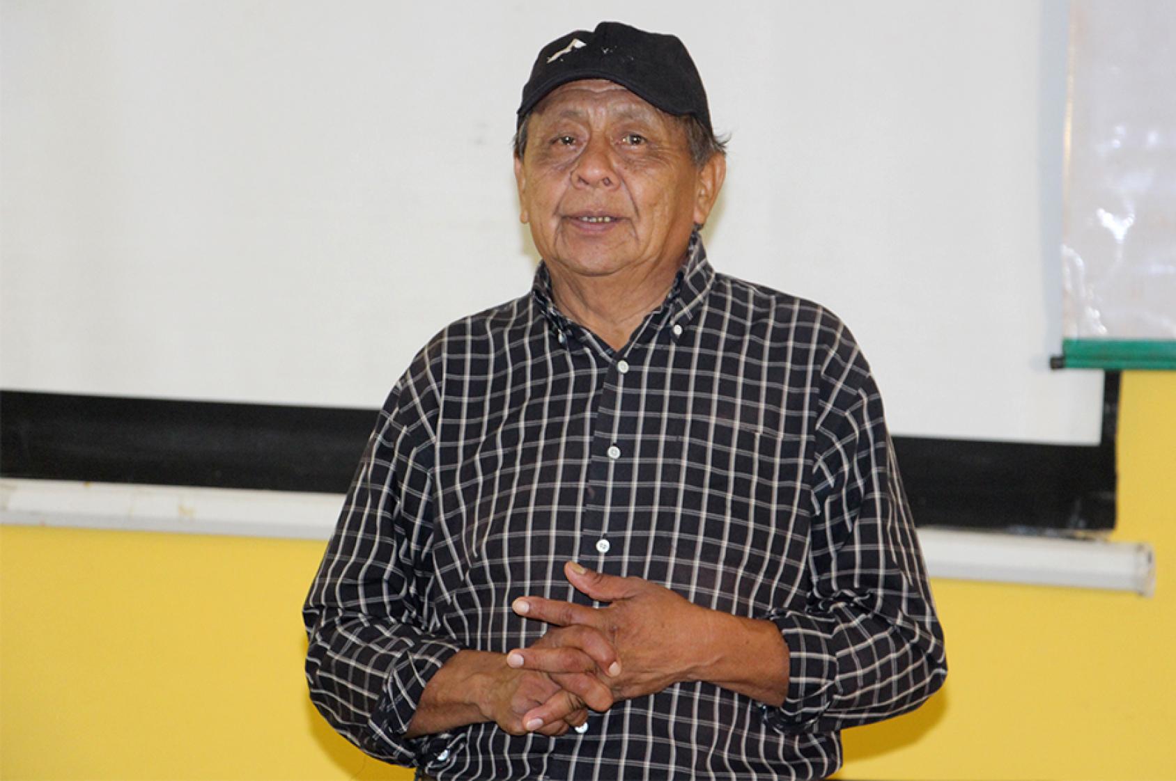 Мужчина в кепке (Иполито Асевей) на фоне белого полотная для проектора 