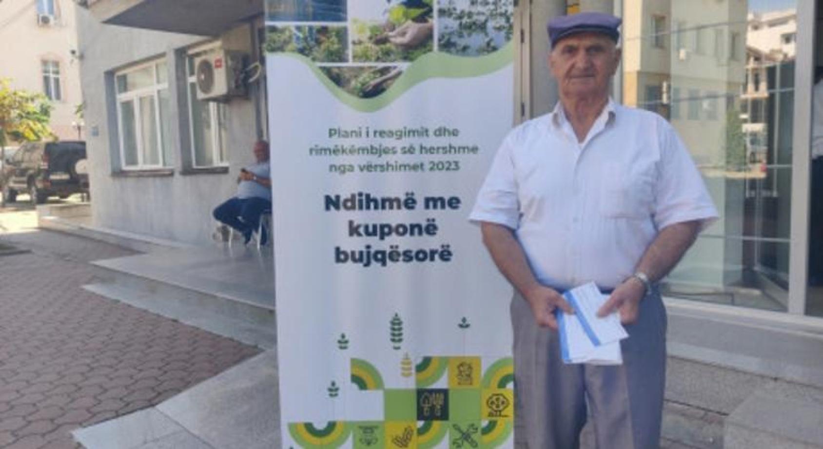 Пожилой мужчина стоит на фоне баннера ФАО