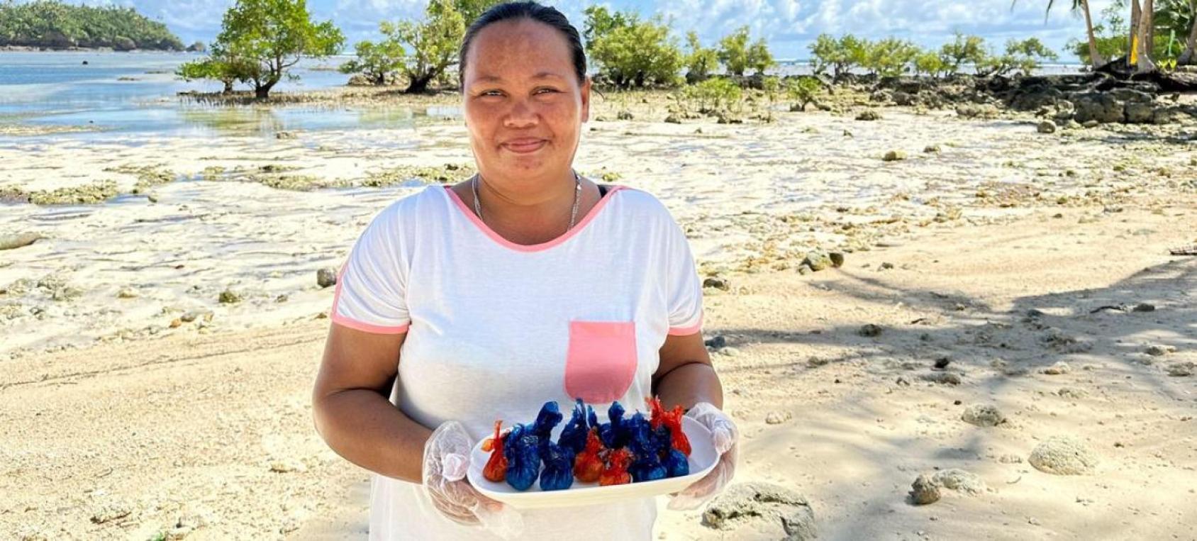A woman in a white shirt carries a plate of fruit candy