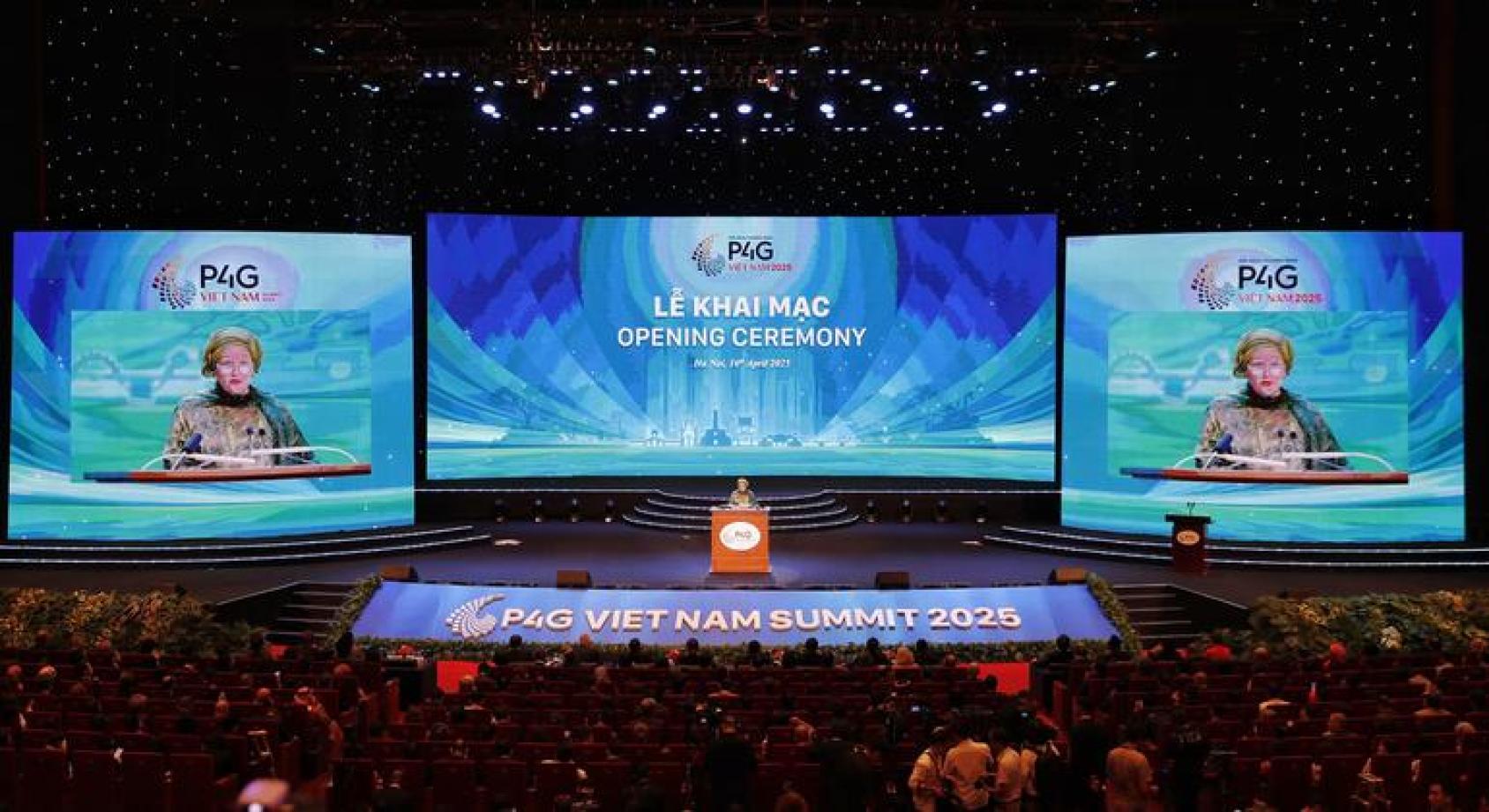 联合国副秘书长在一个大会上演讲，后面是左中右三块大屏幕