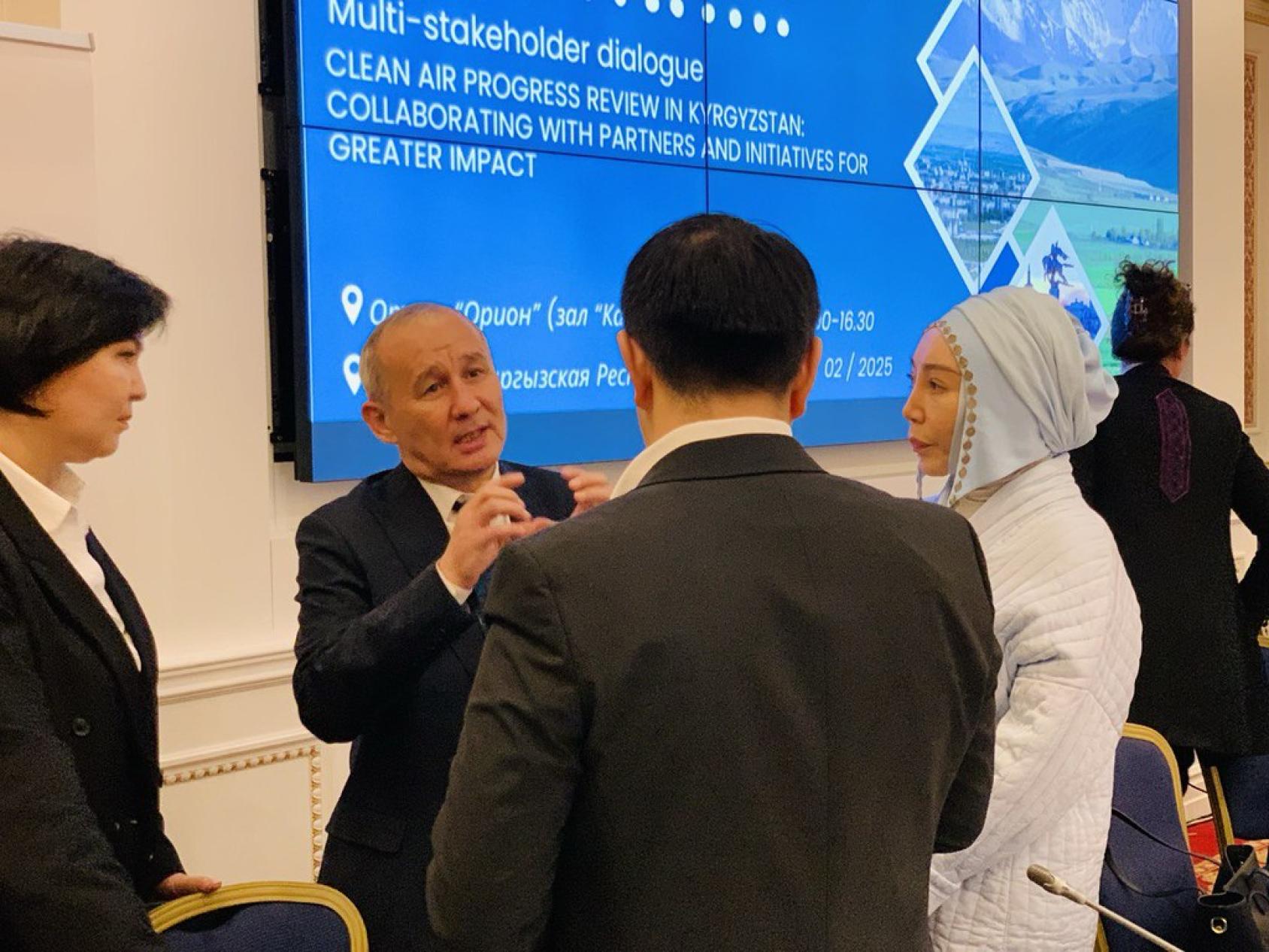 A person is speaking to a group of people in an indoor setting. 