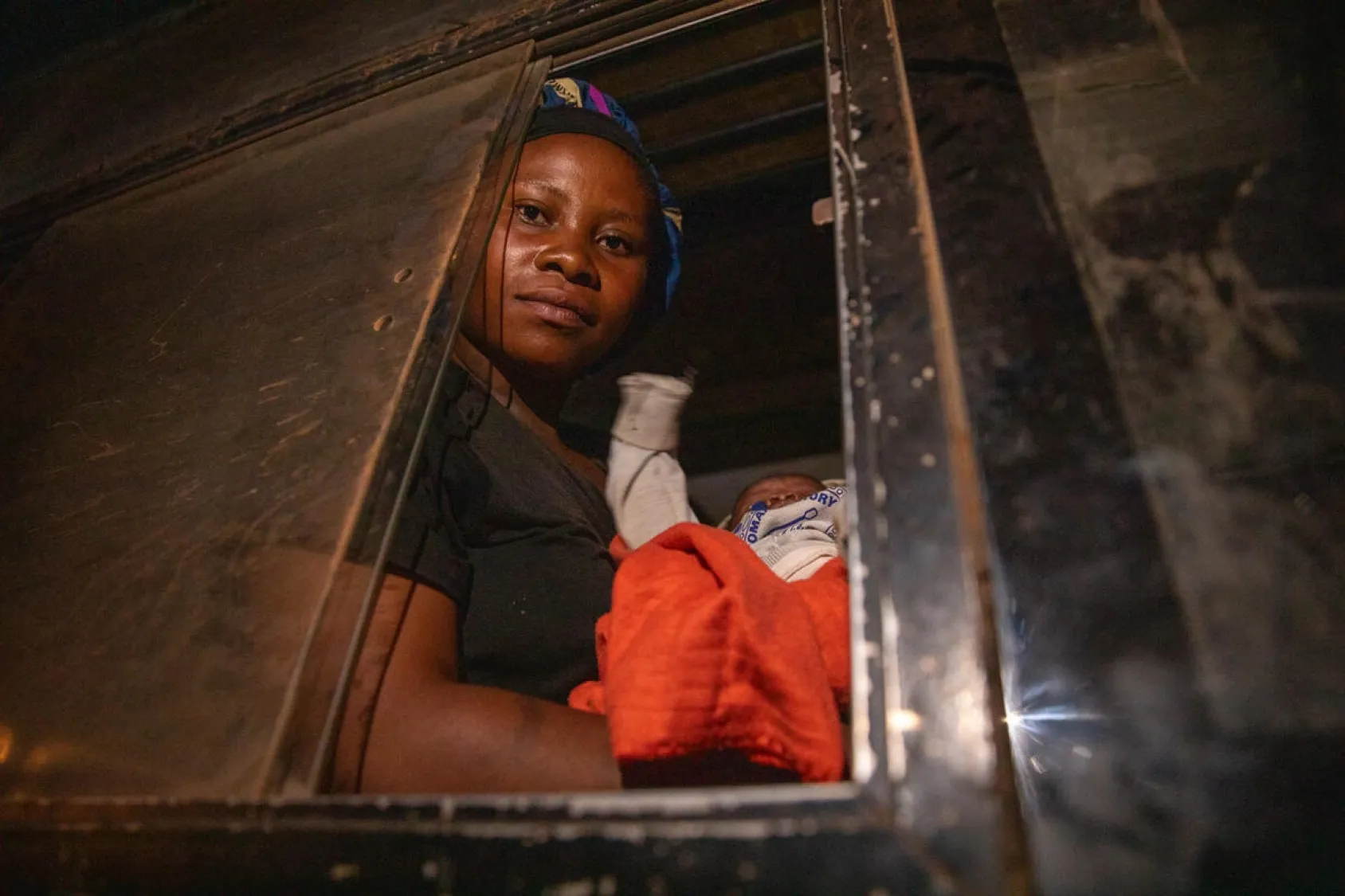 Chancelline tient son bébé dans ses bras à leur arrivée en bus au site de réfugiés de Musenyi, dans le sud du Burundi.