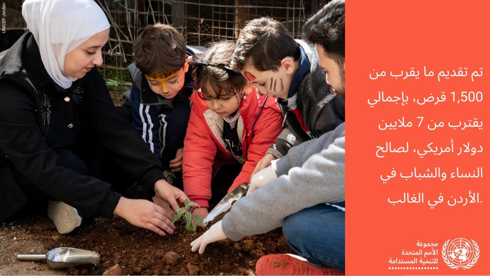 امرأة وأطفال يزرعون نبتة صغيرة في الأرض، في نشاط مجتمعي يدعمه برنامج الأمم المتحدة الإنمائي في الأردن.