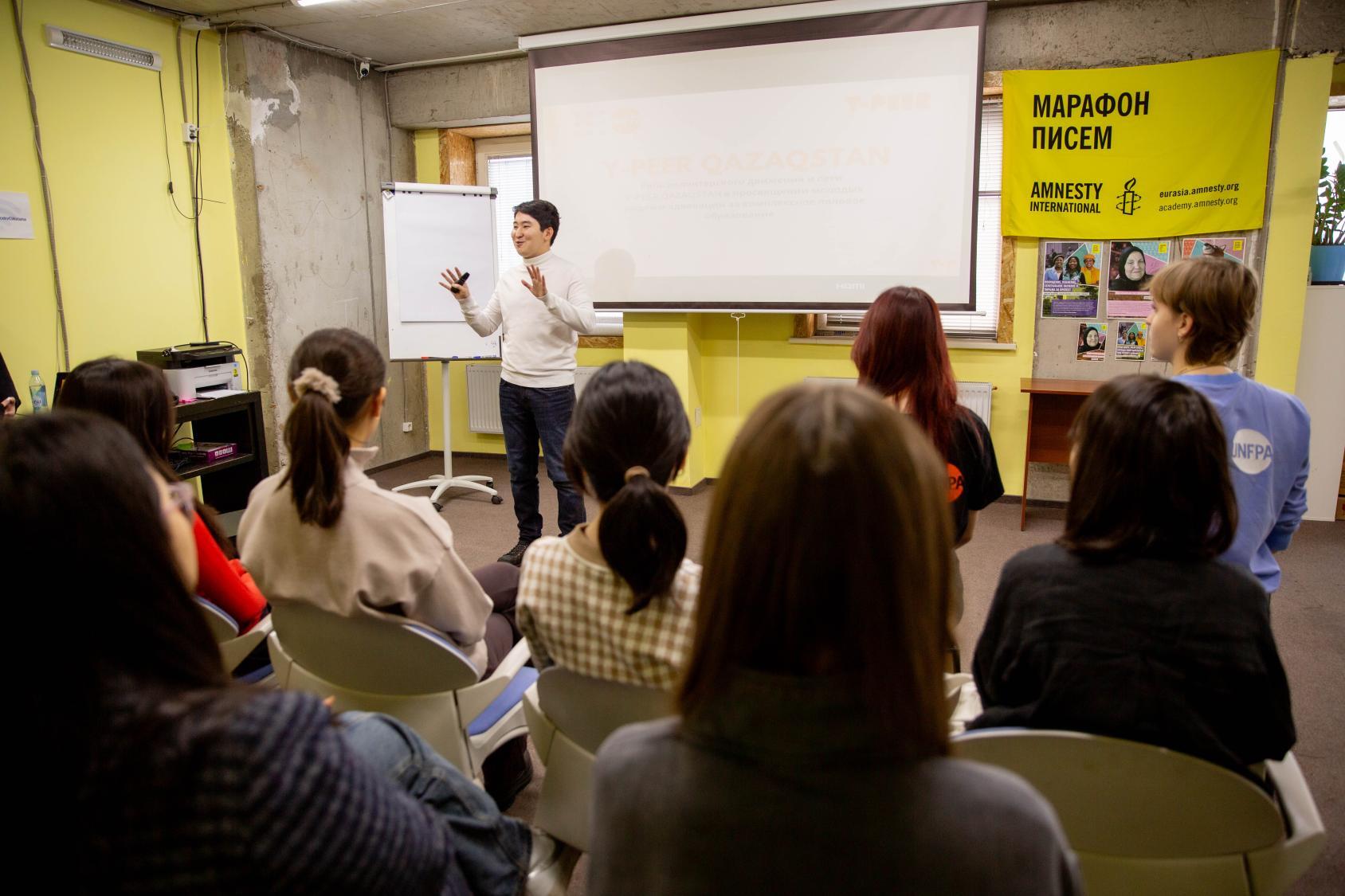 Человек говорит со студентами в аудитории