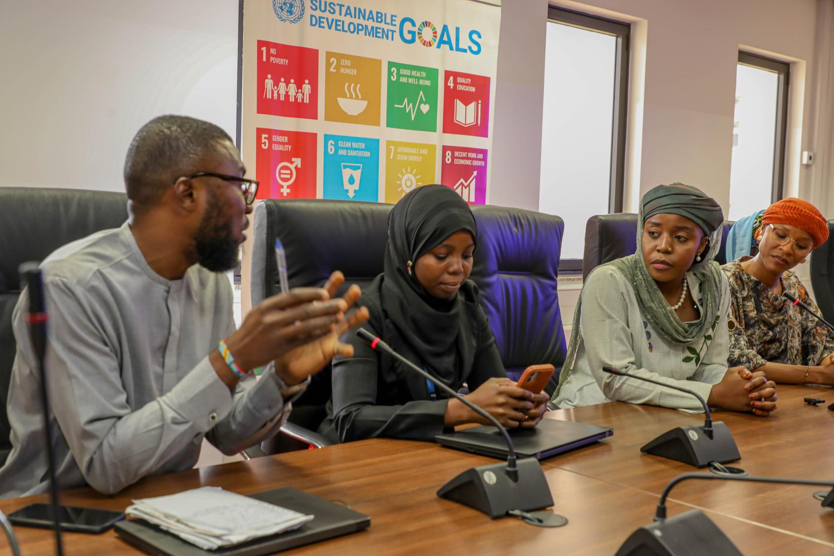 A group of young people in discussion around a table.