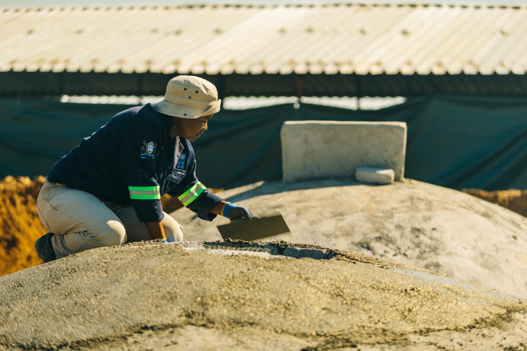 A woman is tending to a biogass well