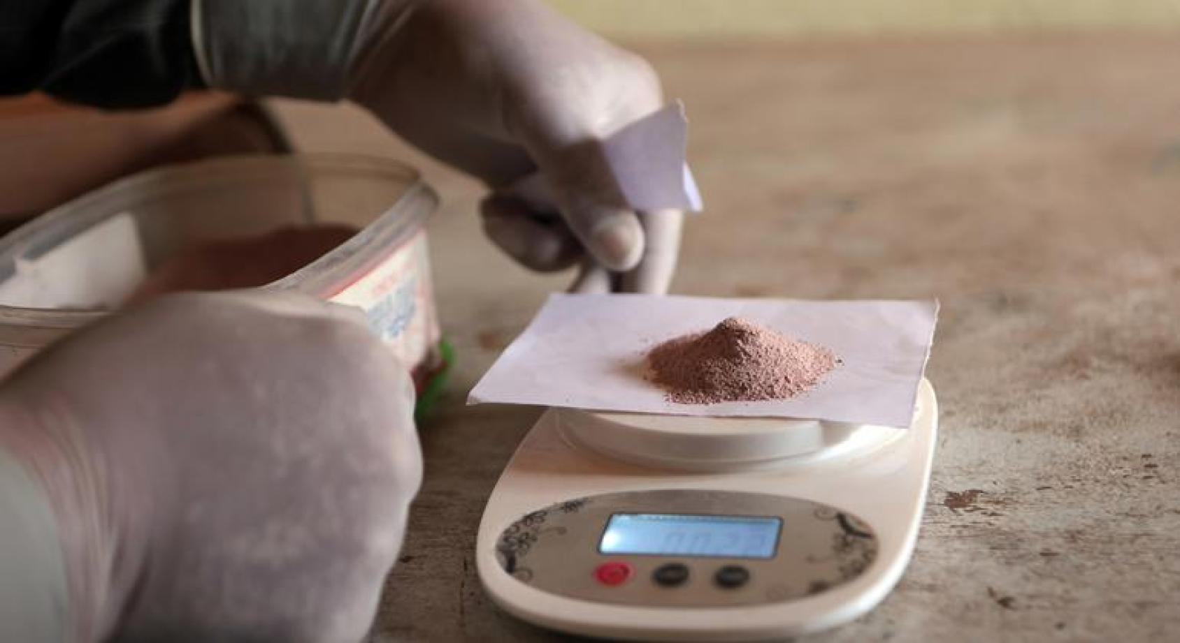 Мужчина взвешивает лекарство