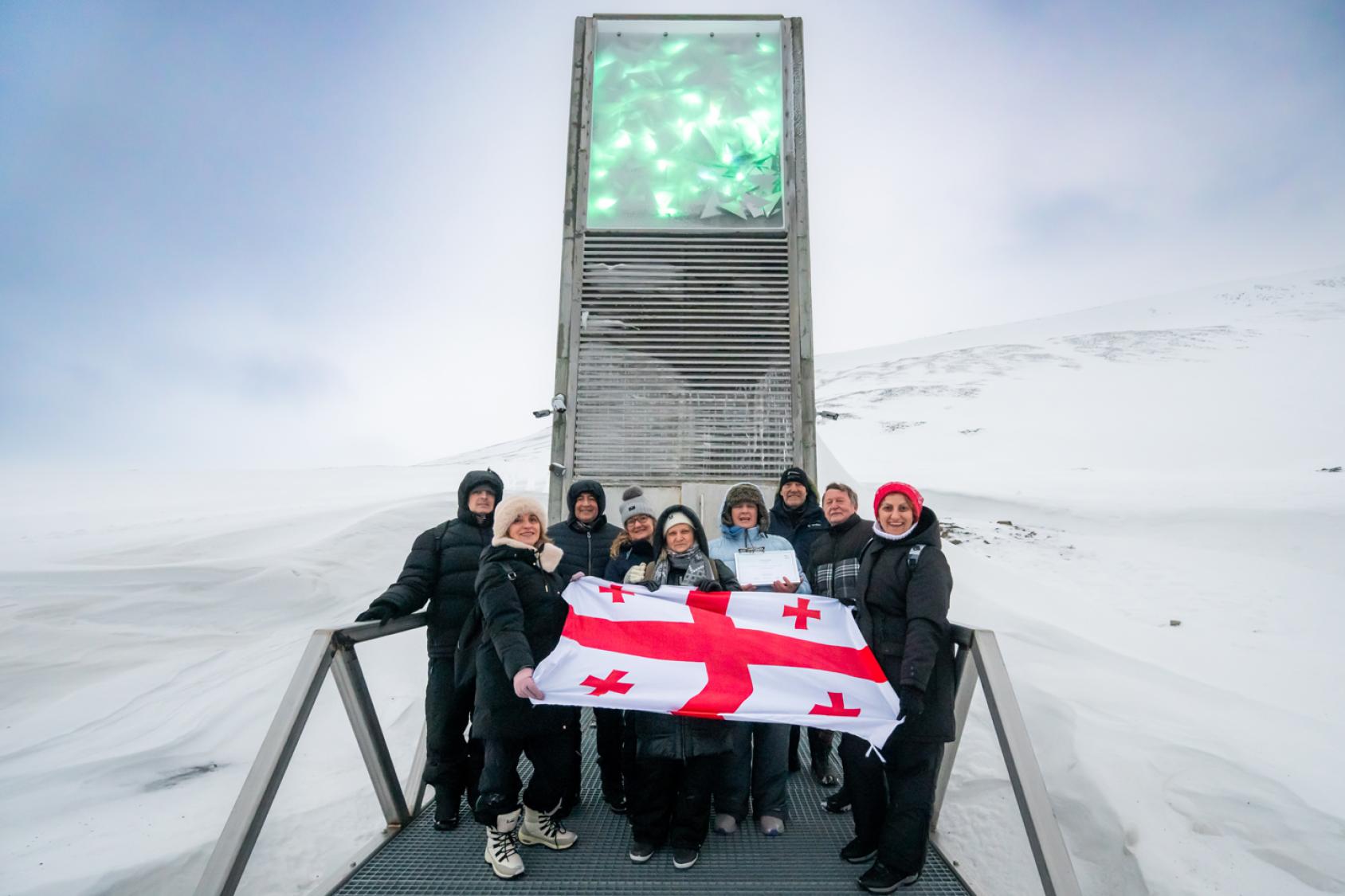 People holding the Georgian flag in front of the Svalbard Global Seed Vault