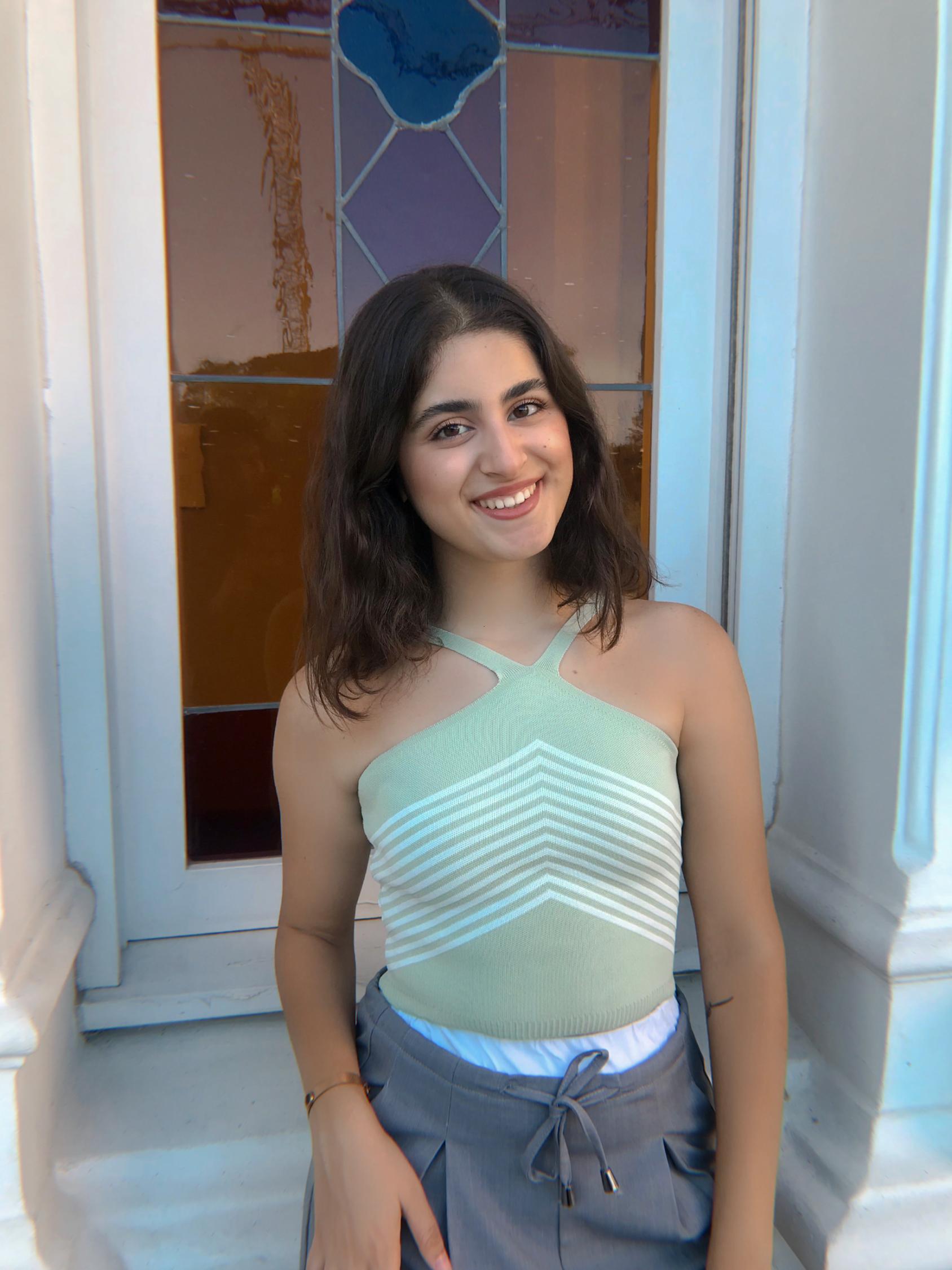 A woman in a green shirt and grey trousers