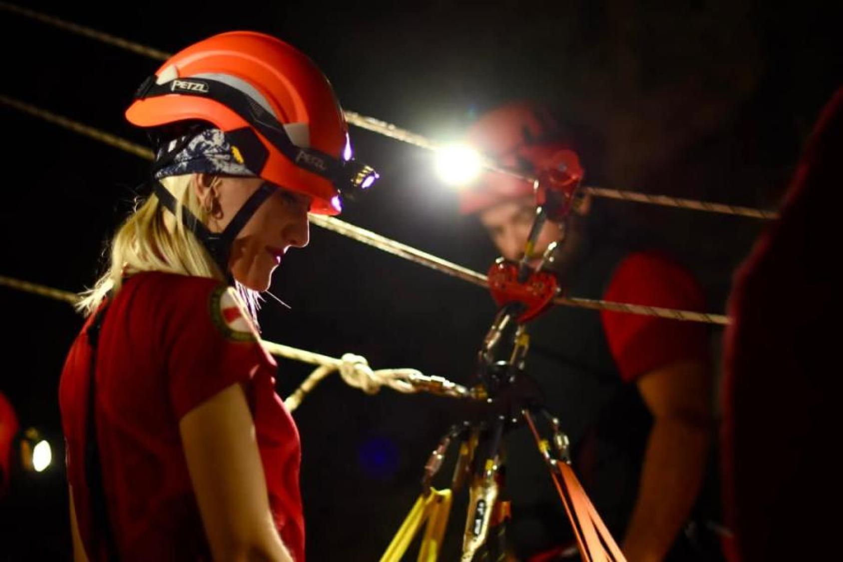 A woman undertaking a mountain rescue in the dark