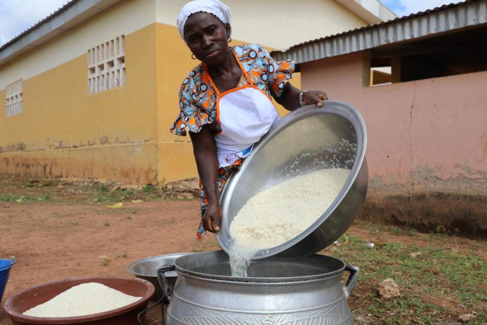 Une cantinière de l'école EPP Nangasseregué, école bénéficiaire des vivres fournis par PAM, prépare activement le repas de midi pour les élèves inscrits