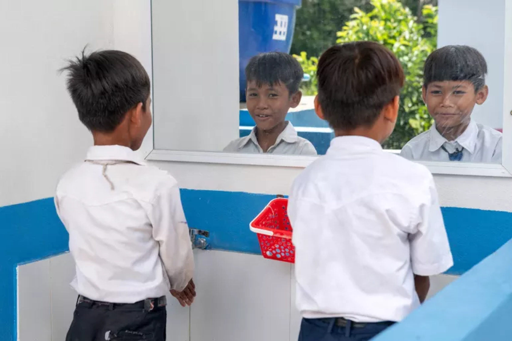 Grâce à l’inclusion de miroirs dans les installations WASH, des élèves comme Hort Lita (à gauche) et Ly Dany ont davantage de fierté et de confiance lorsqu’ils vont à l’école.