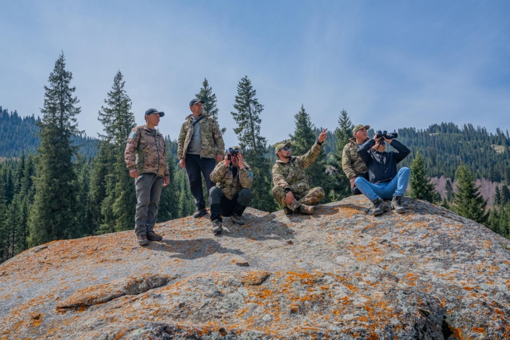 Мужчины стоят на большом камне