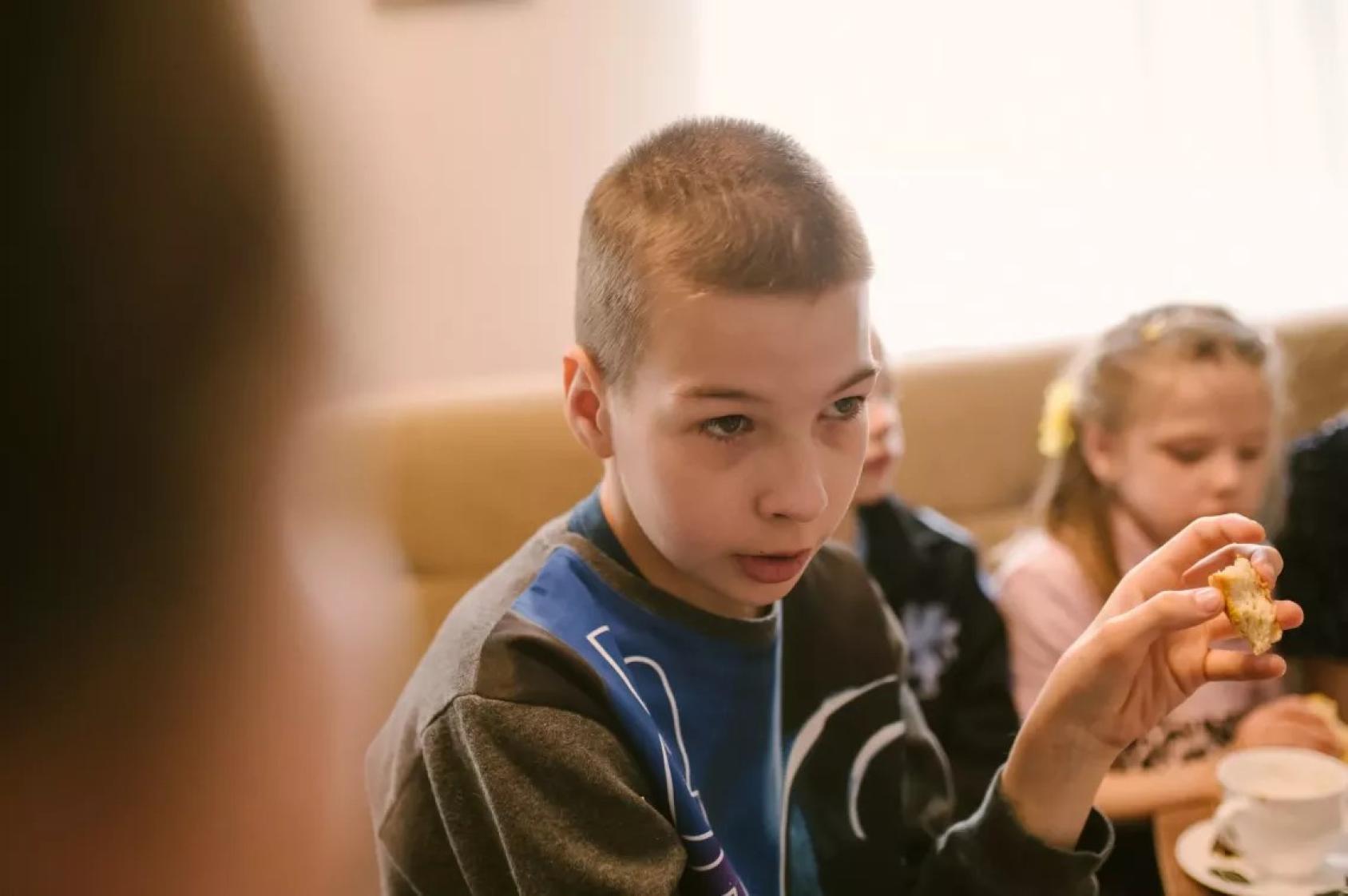 Мальчик ест хлеб и разговаривает