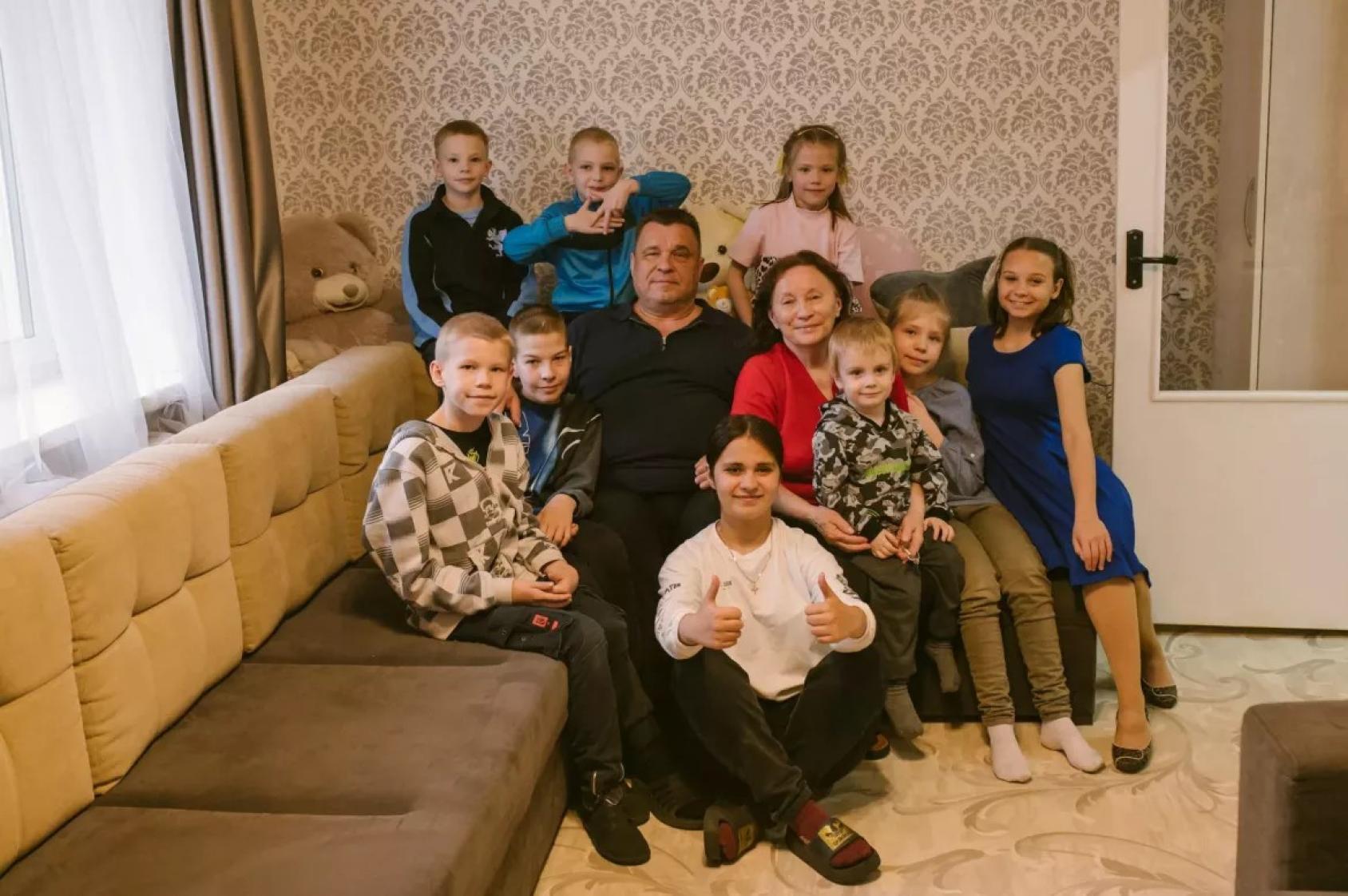 Семья сидит на диване и улыбается