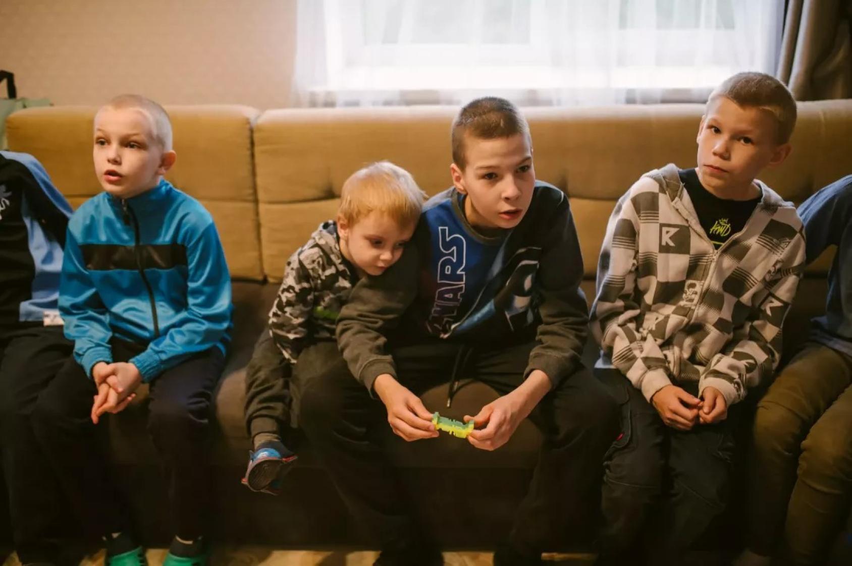 Мальчишки болтают, сидя на диване