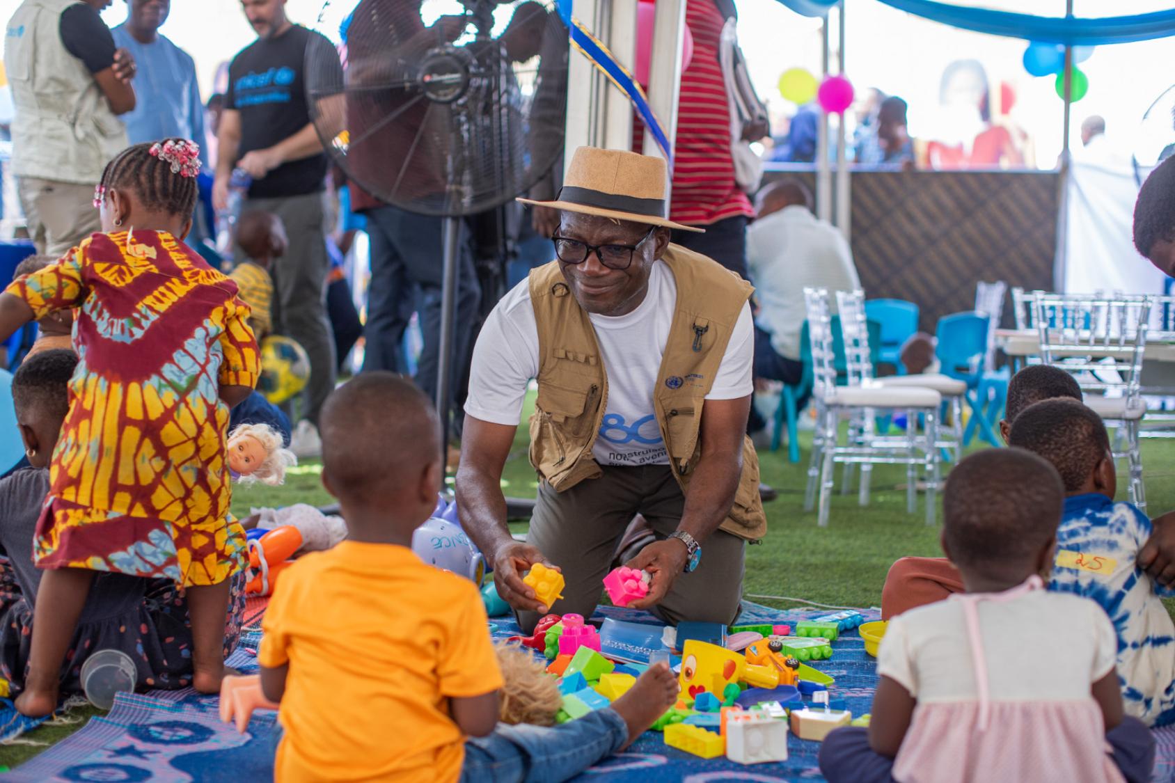 A man in Togo plays with young children.