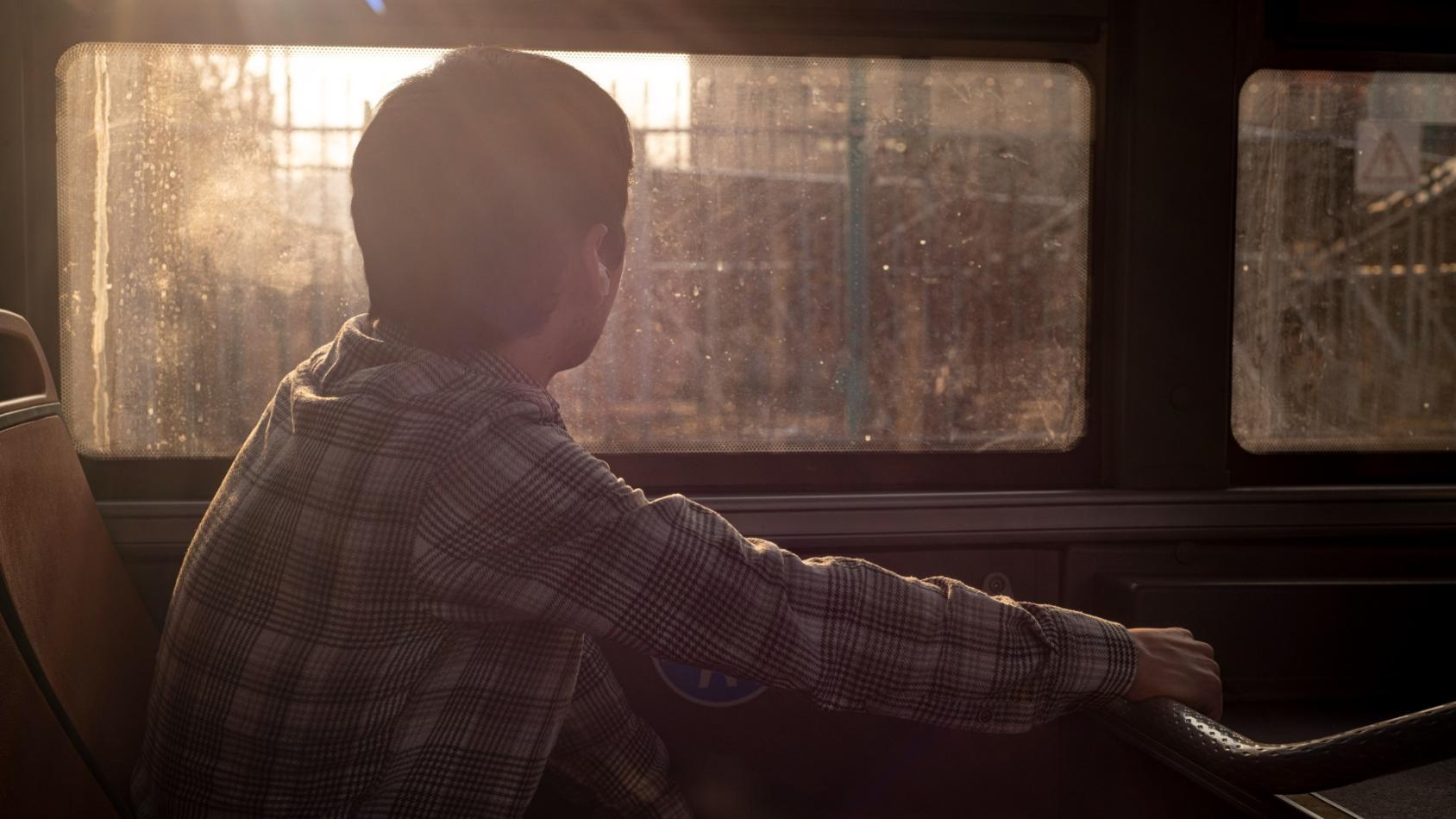 Мужчина едет в автобусе и смотрит в окно