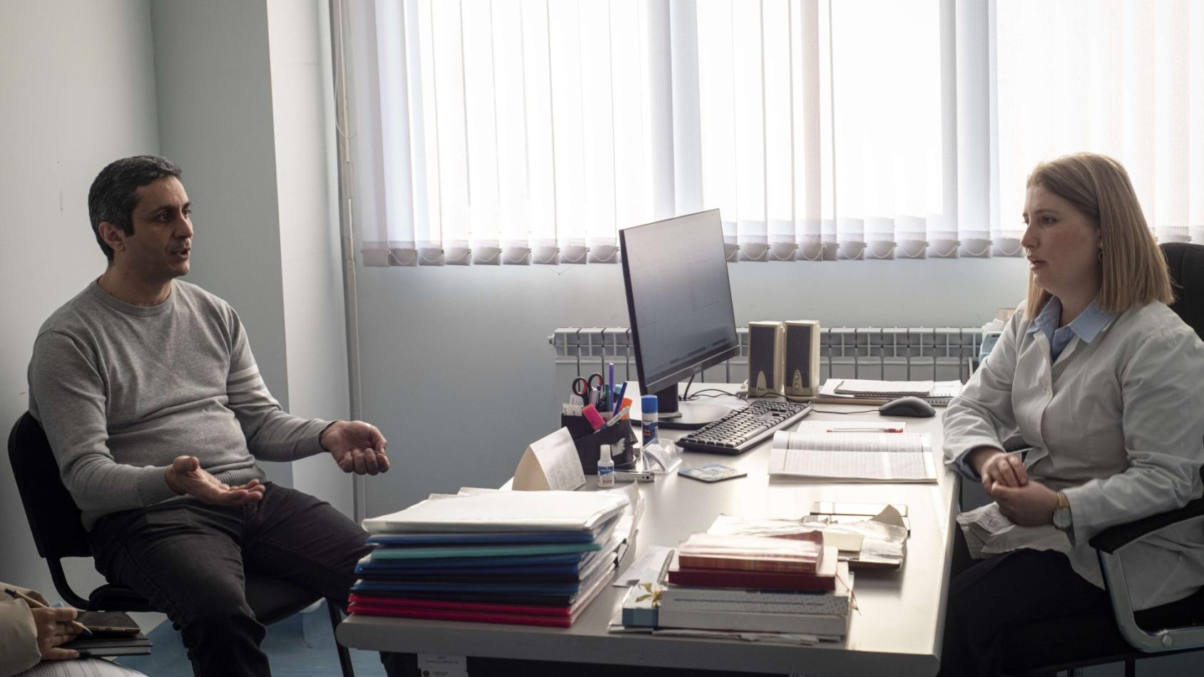 Мужчина сидит напротив врача в кабинете