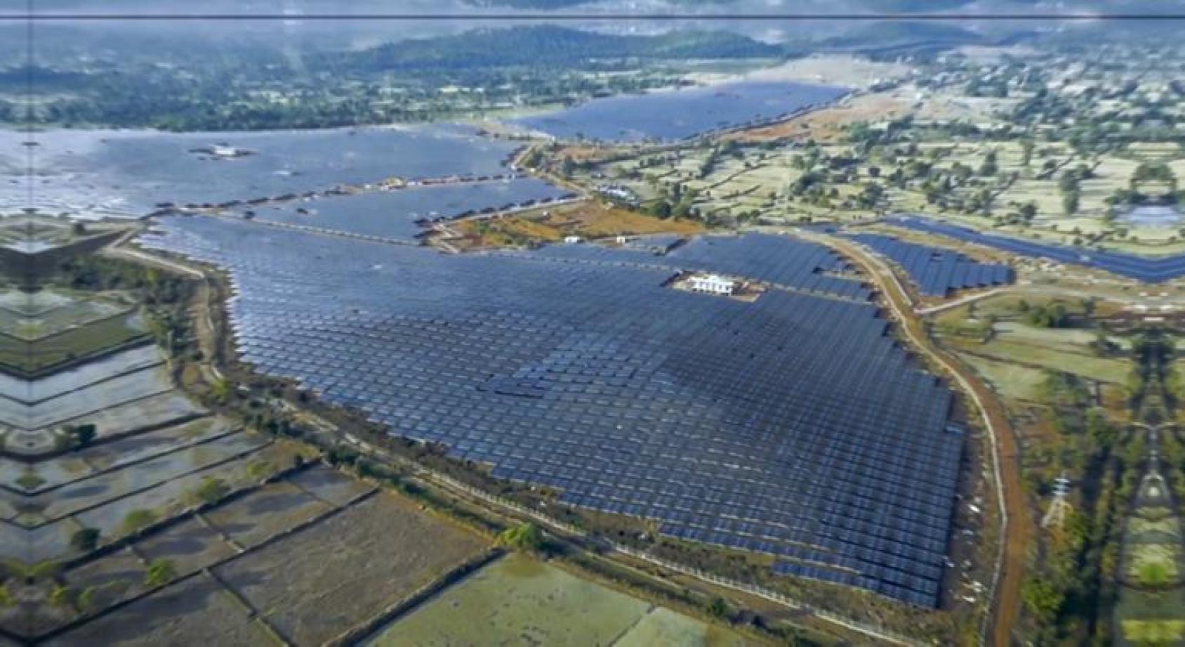 一大片太阳能光伏板在绿色田野中