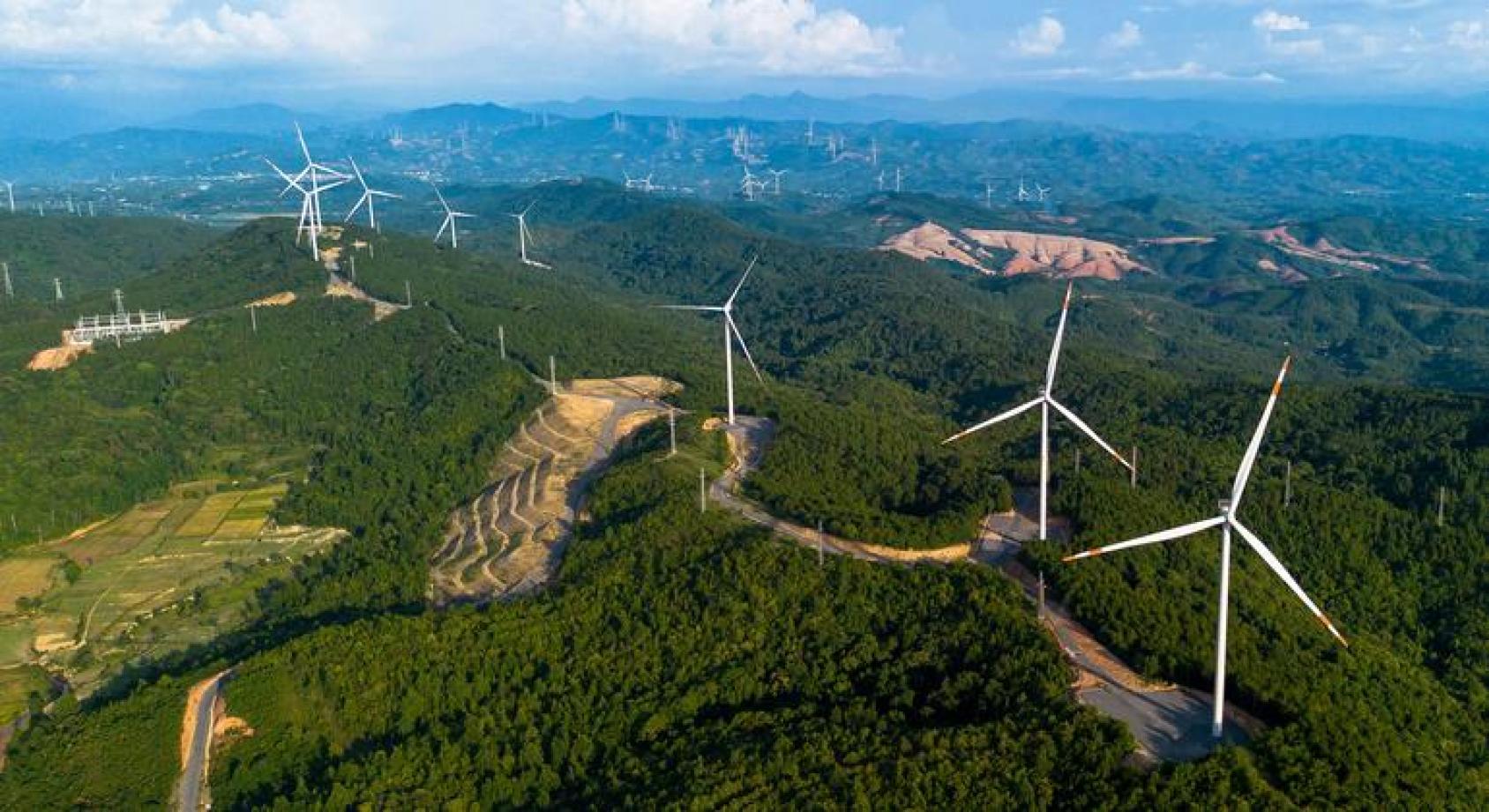 一片绿色的山坡田野上，有若干个巨大的风车叶片