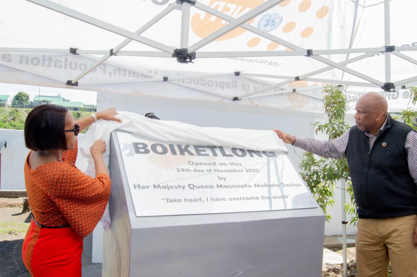 The King and Queen of Lesotho unveil a sign commemorating a women's shelter.
