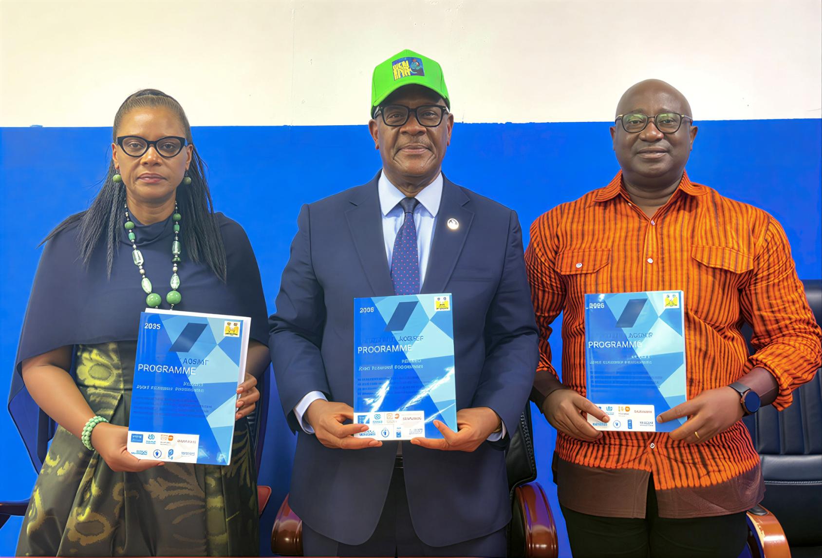 Three high-level officials pose for a photo in Sierra Leone while holding copies of a health policy. 