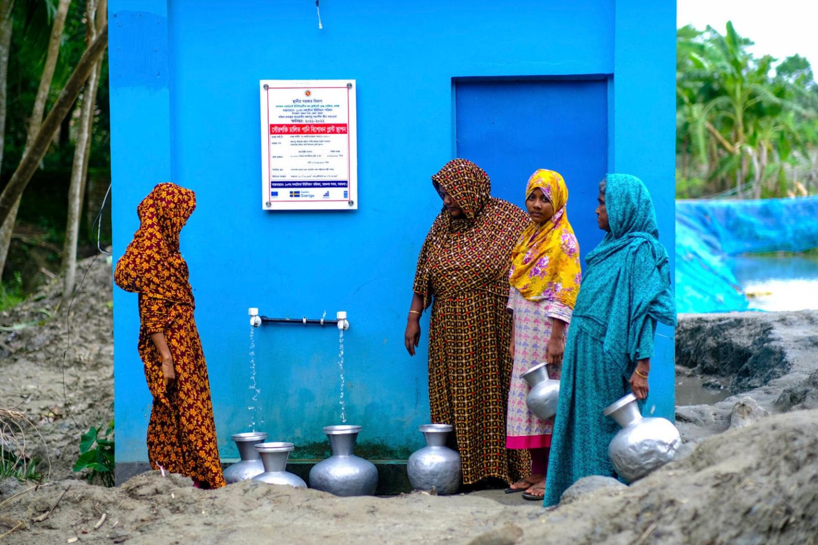 Women in Bangladesh collect water from a tap.