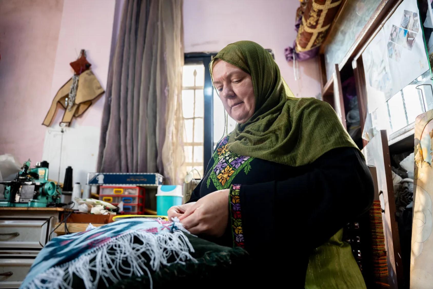 امرأة في الأردن تُطرز سجادة.