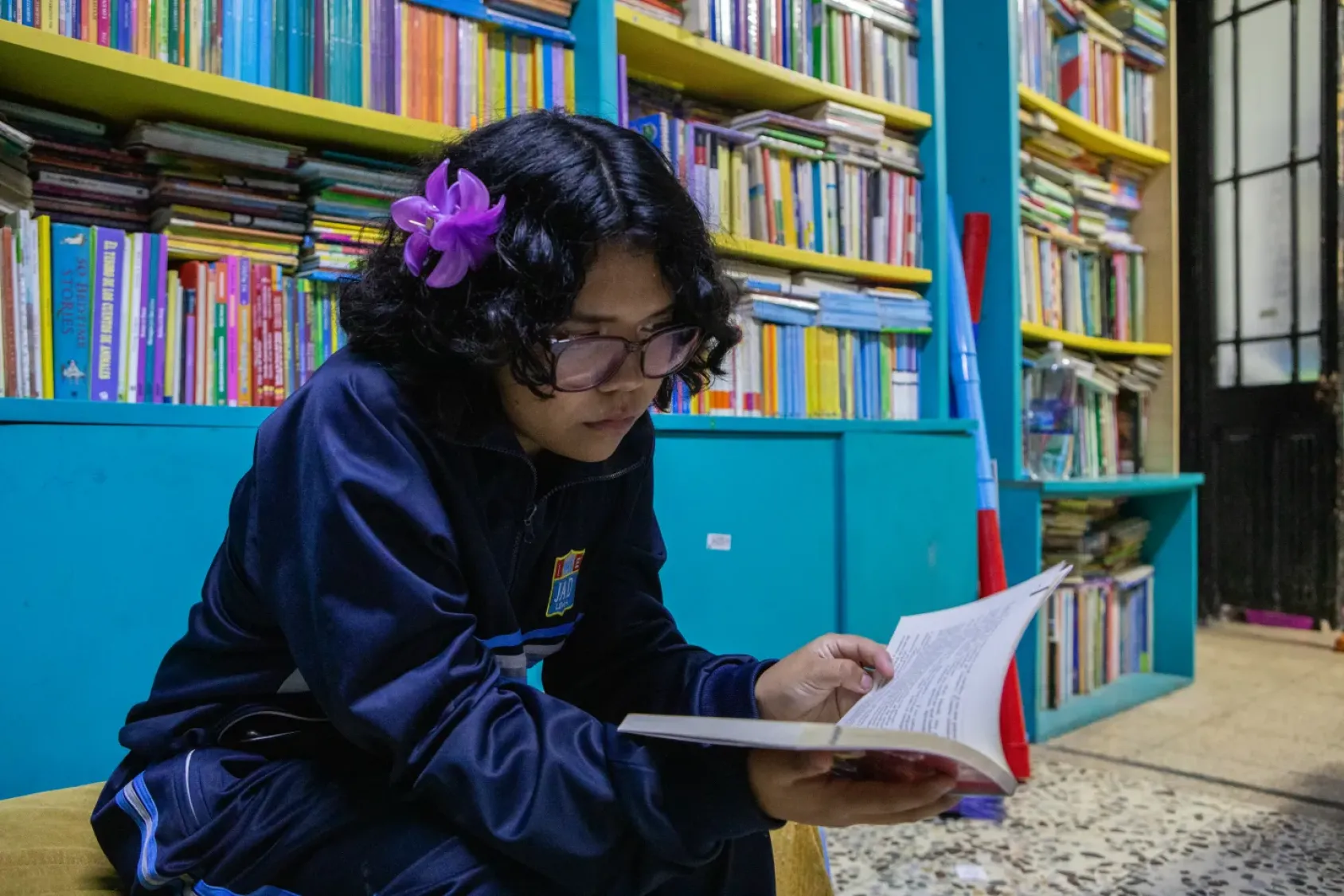 Niña lee en la biblioteca