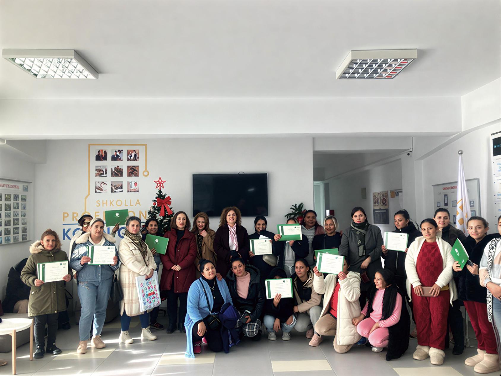 A group of women in Albania pose with their vocational training certifications.