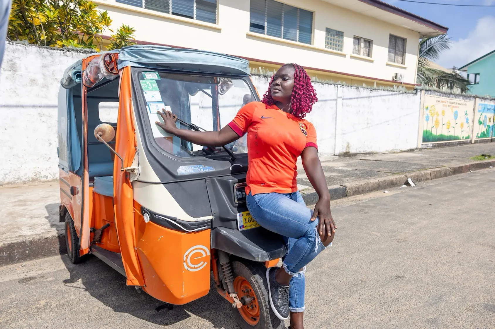 Elvis, la conductrice d’un tuk-tuk électrique à Monrovia, au Libéria, incarne une mobilité propre portée par les jeunes, alliant action climatique, inclusion des femmes et moyens de subsistance durables.