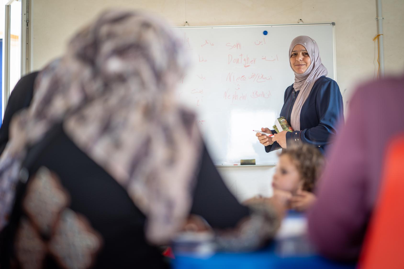 A woman in Jordan delivers a class to students.