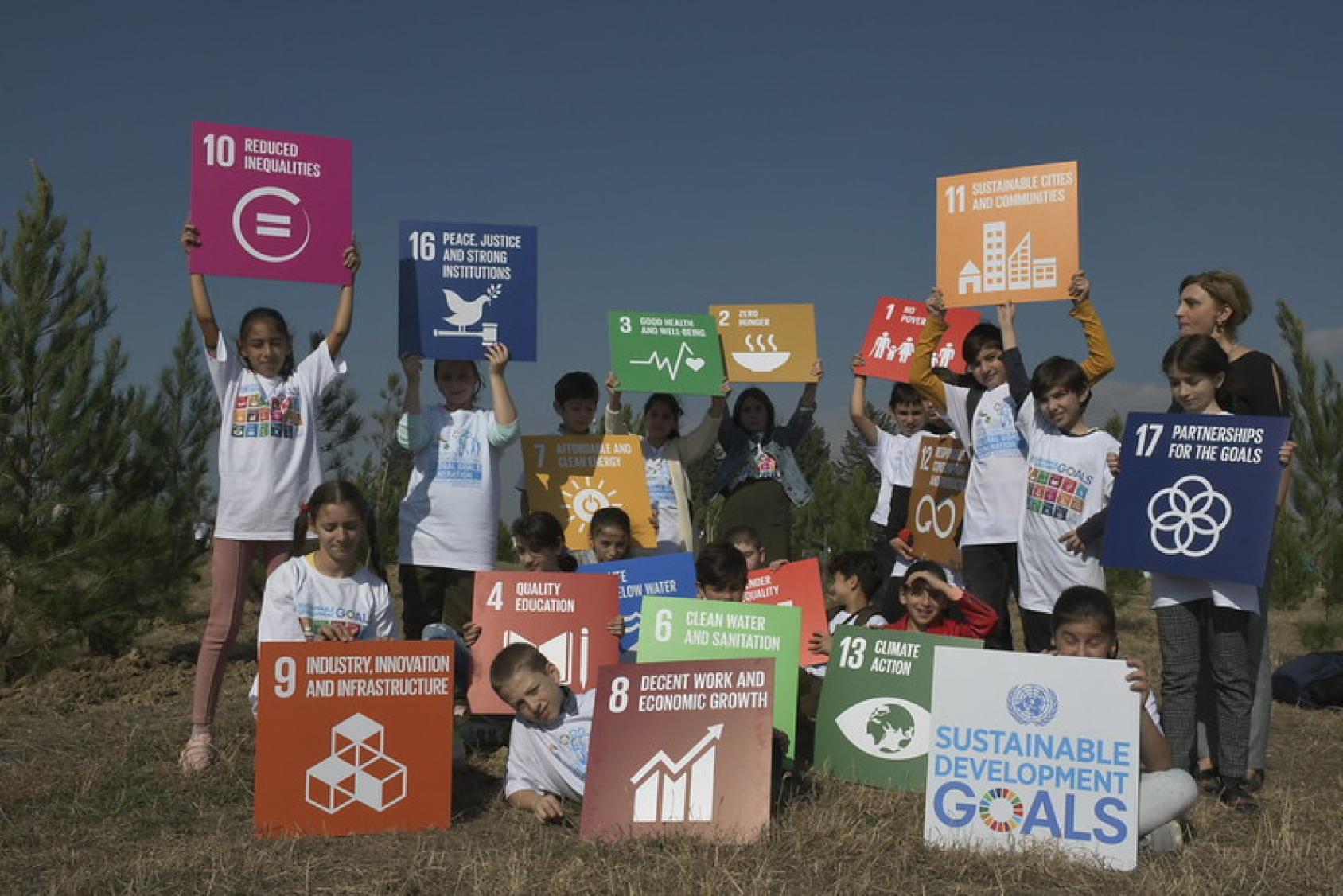 A group of kids in Georgia hold SDG signs.