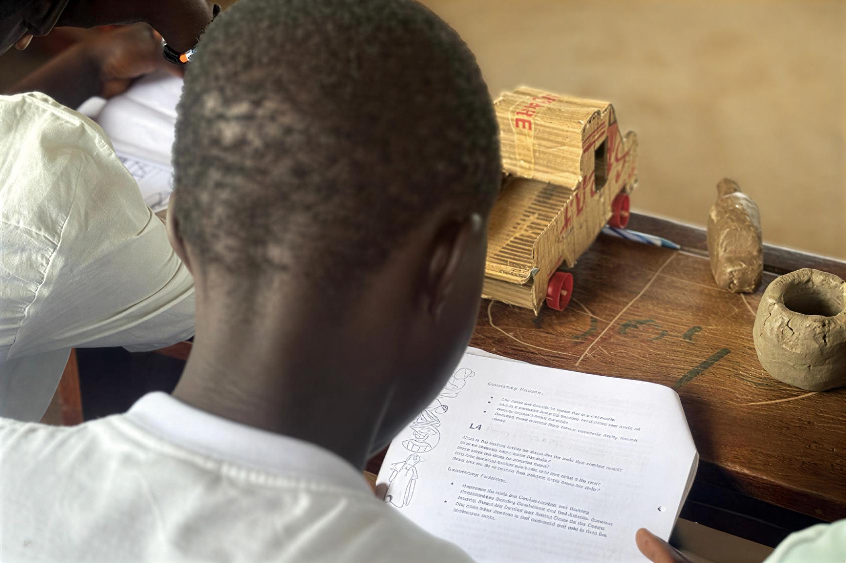 A girl at a school in Uganda reads a paper.