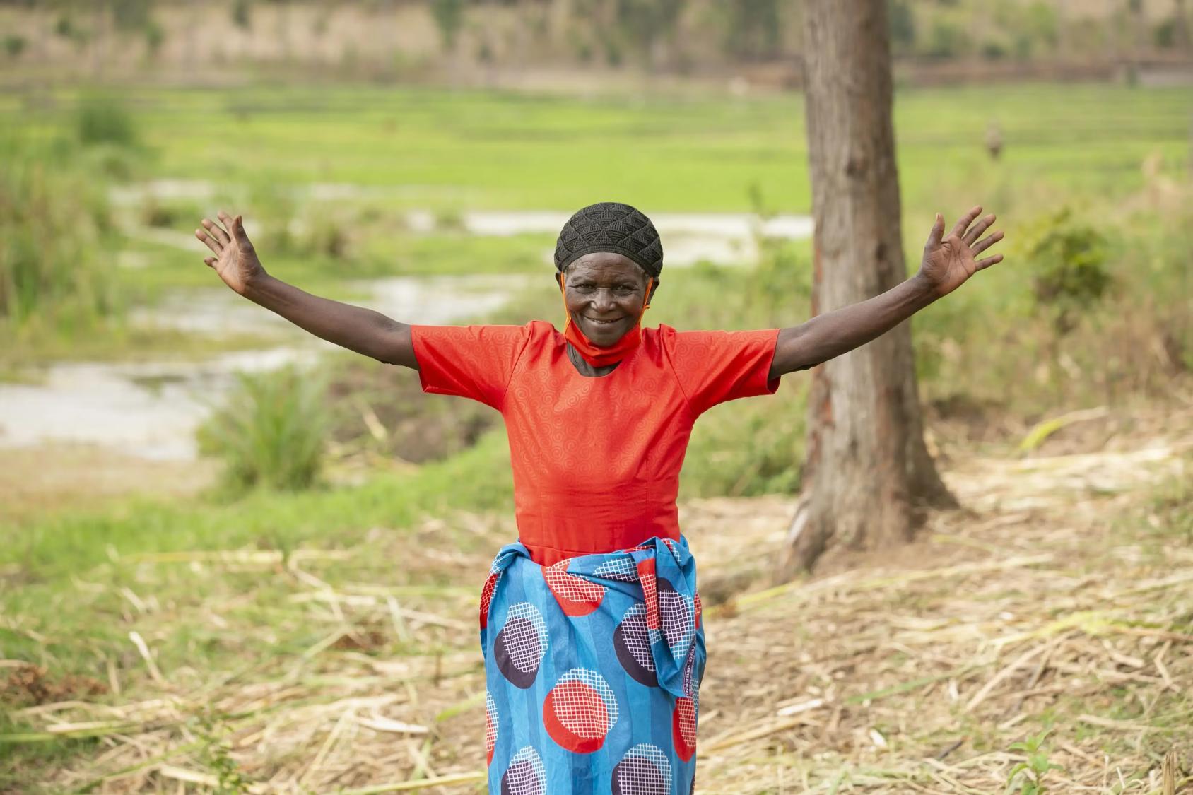 A woman happily holds out her arms.