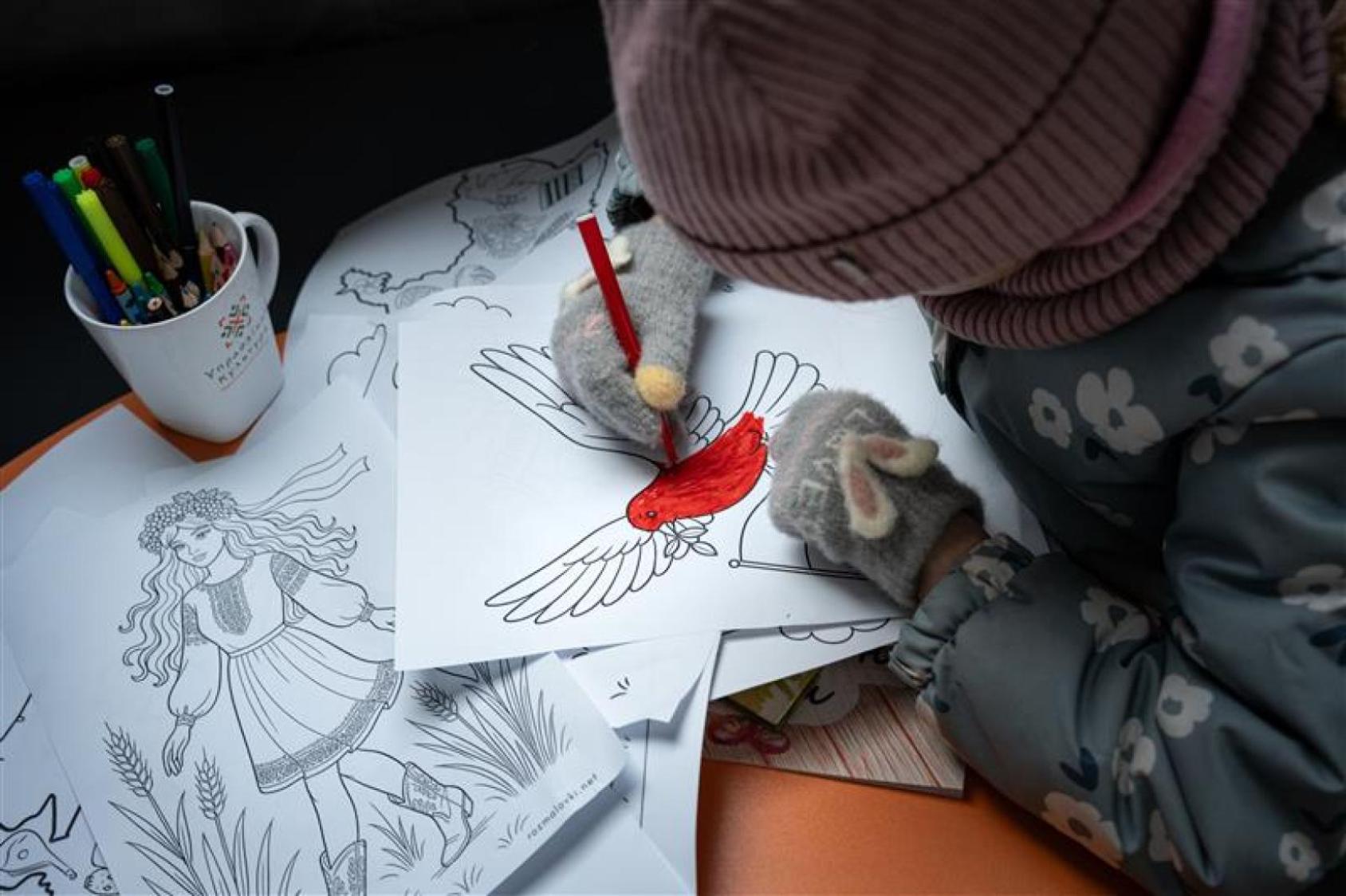 A girl in Ukraine paints a peace dove.