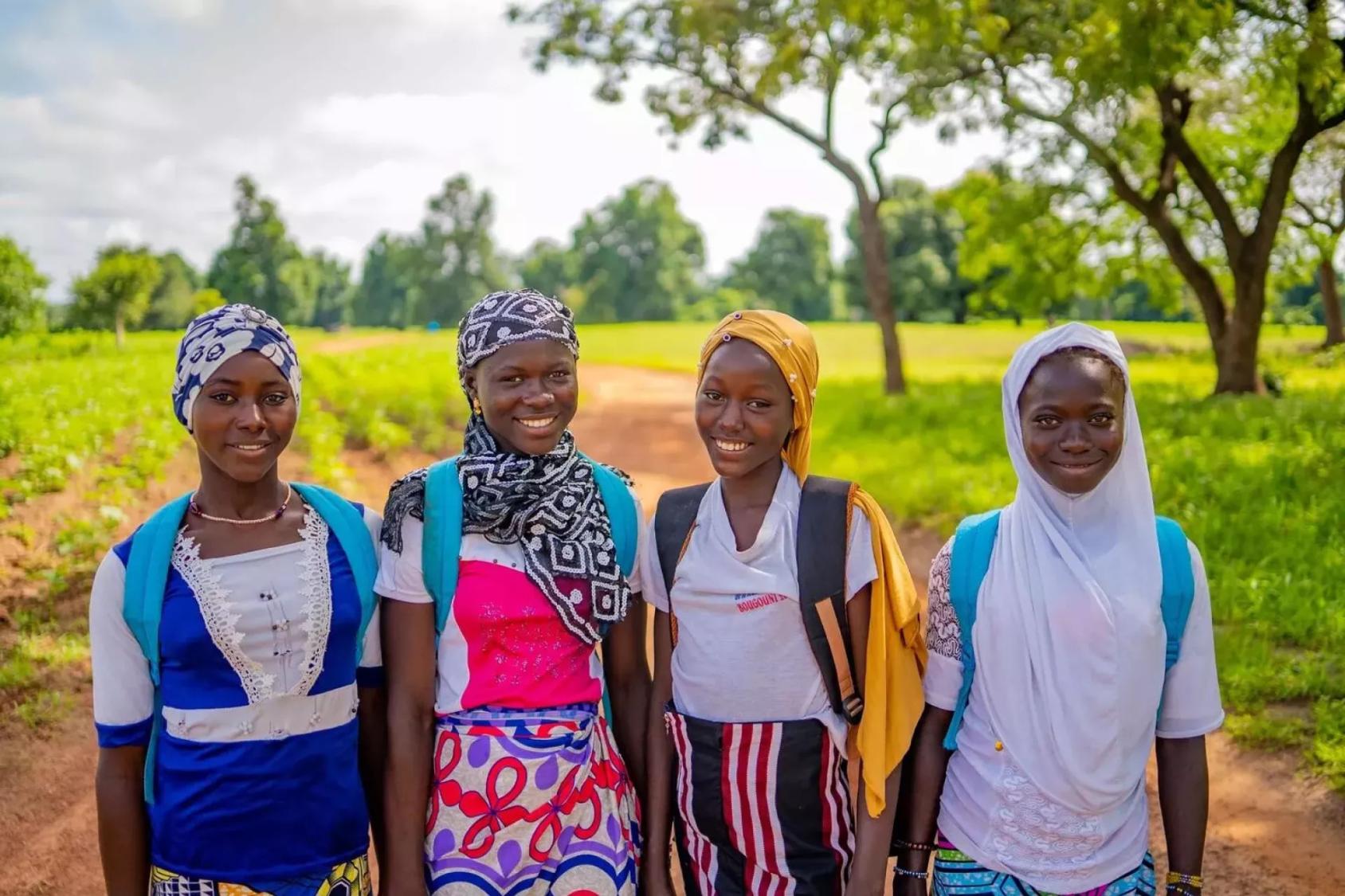 Four school girls smile for a photo.
