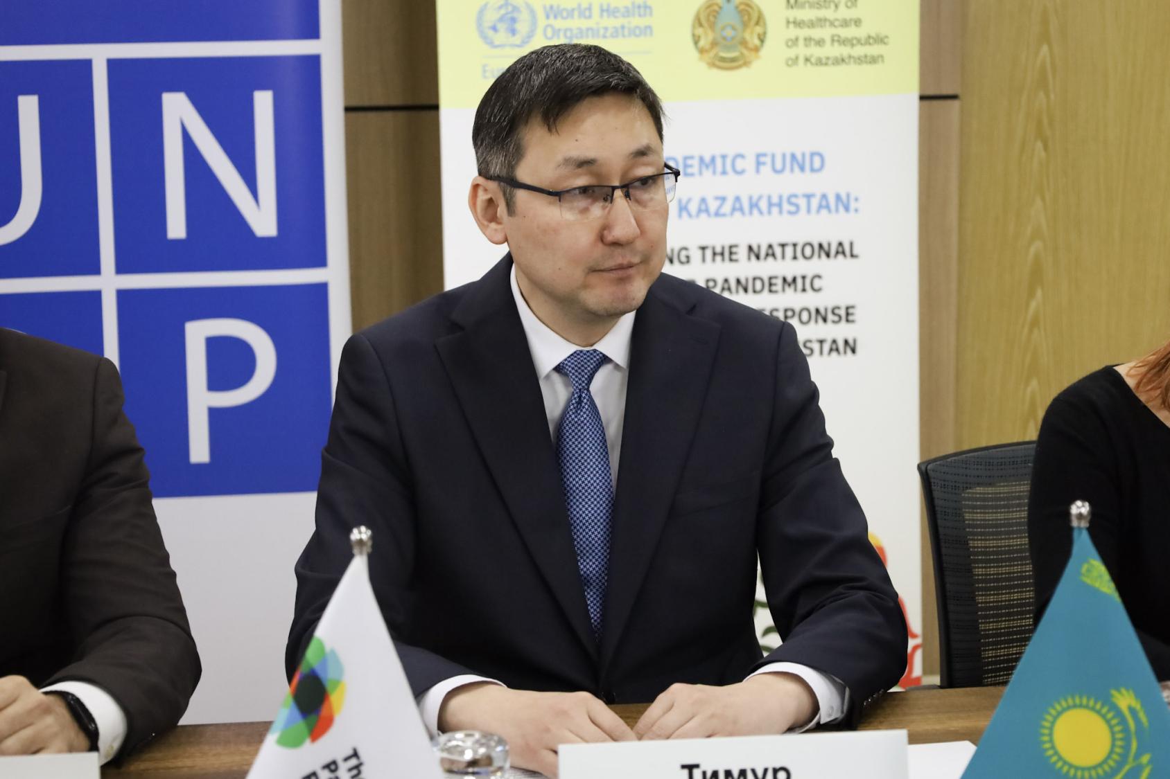 Тимур Султангазиев слушает выступление, сидя за столом.