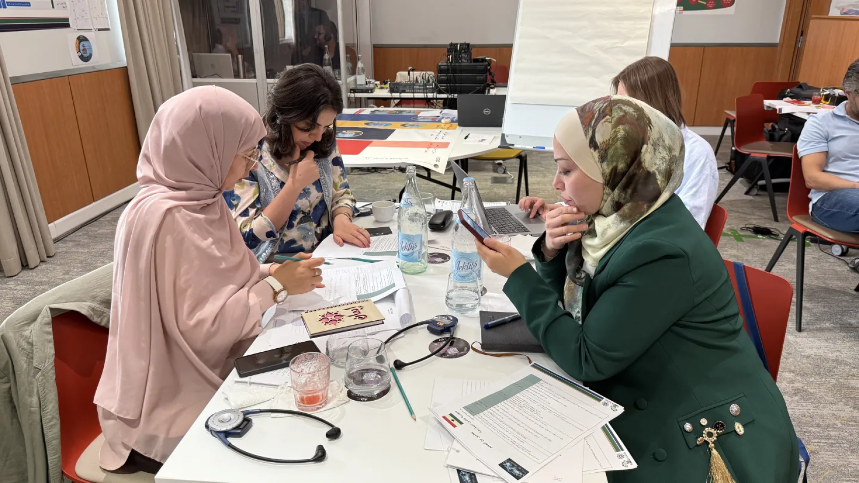 يتجمع المشاركون حول أداة رسم خرائط مرئية لتحليل أطر الحماية الاجتماعية. وقد أتاح هذا التمرين للمشاركين تصور كيفية تفاعل مختلف عناصر بناء السياسات لتشكيل نظام حماية اجتماعية متماسك. تونس، تونس. مايو 2025.