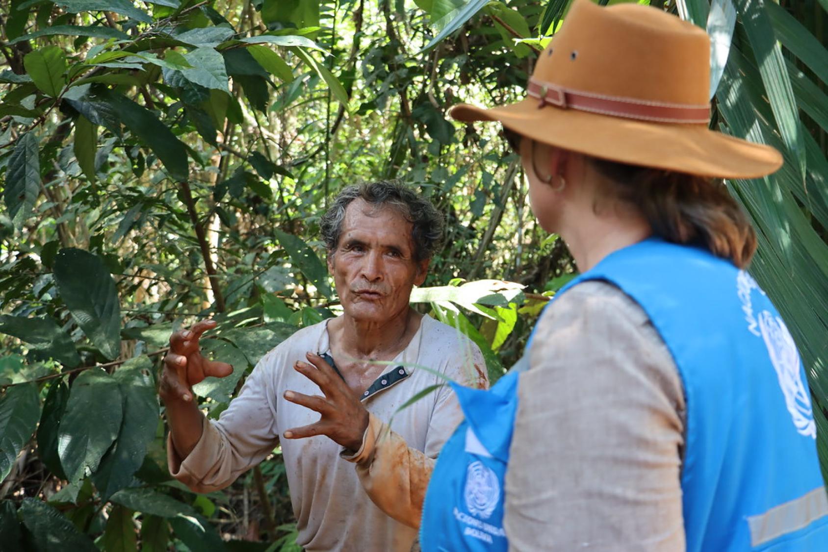 A man in the Bolivian Amazon displays his crop to a UN official.